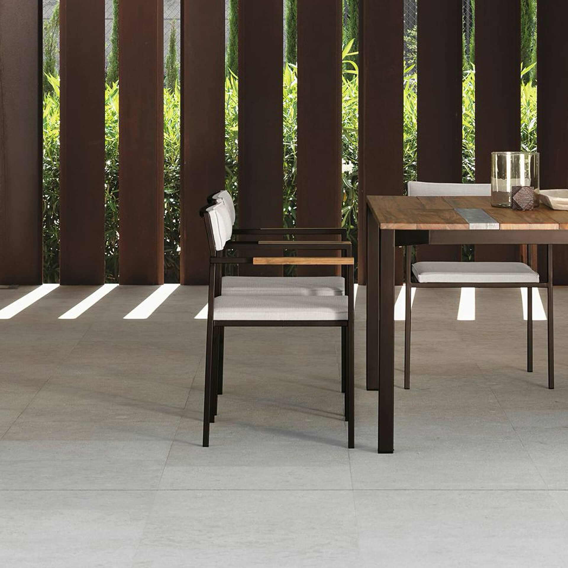 Outdoor dining chair with wooden frame and white cushion.