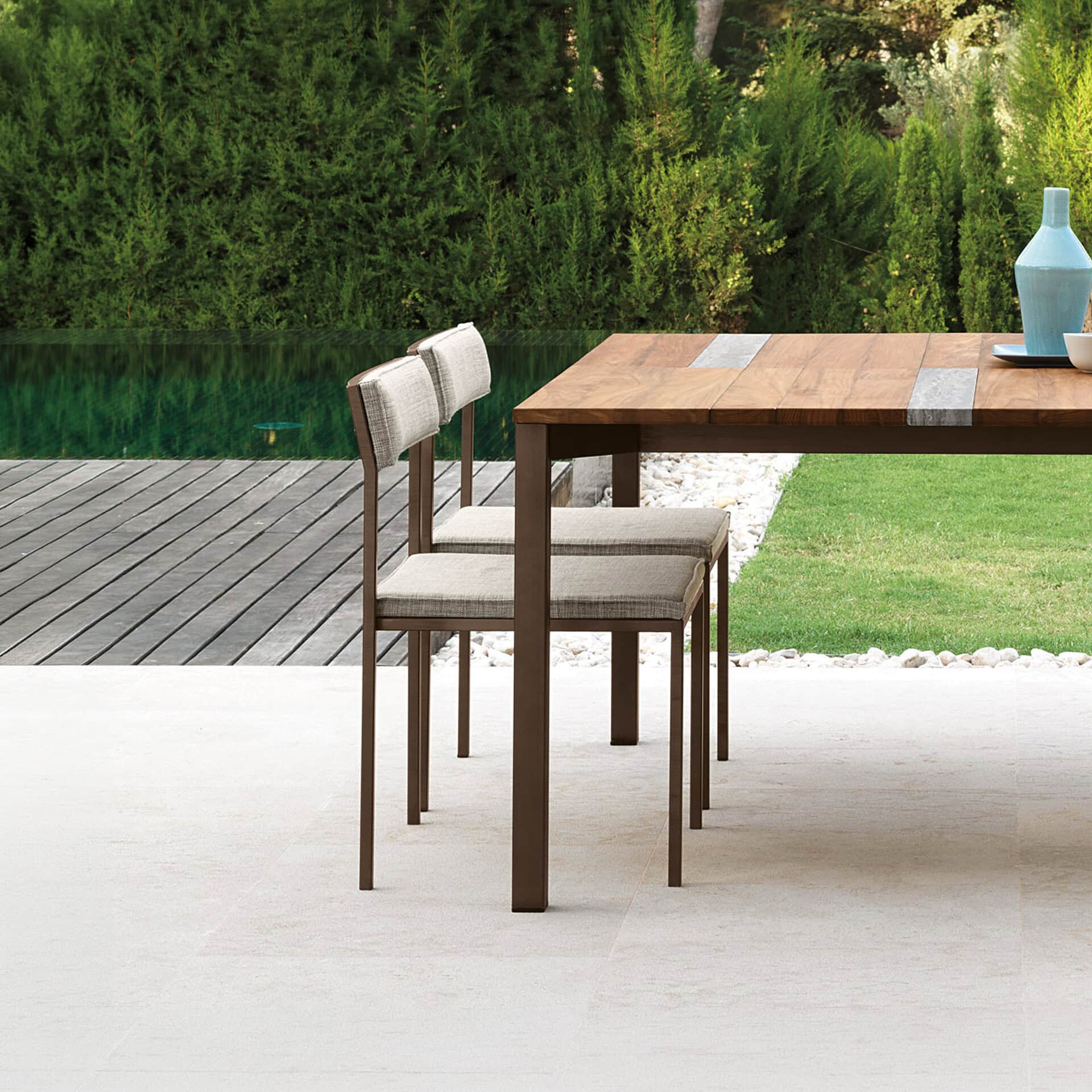 Elegant outdoor dining chairs with neutral fabric cushions and wooden frames.