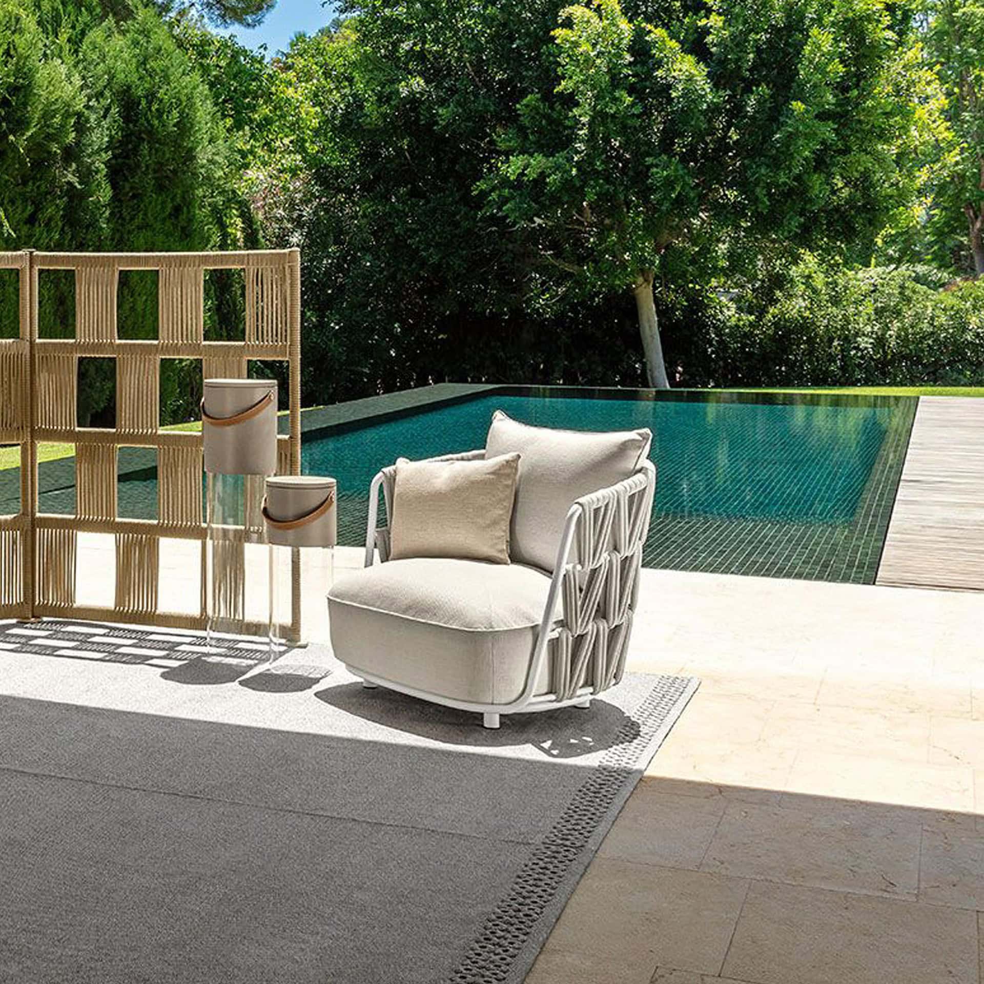 Elegant outdoor lounge armchair for poolside relaxation.
