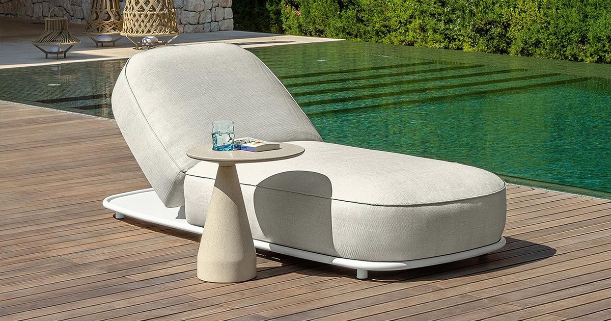 Modern outdoor sunbed with a side table, perfect for poolside relaxation.