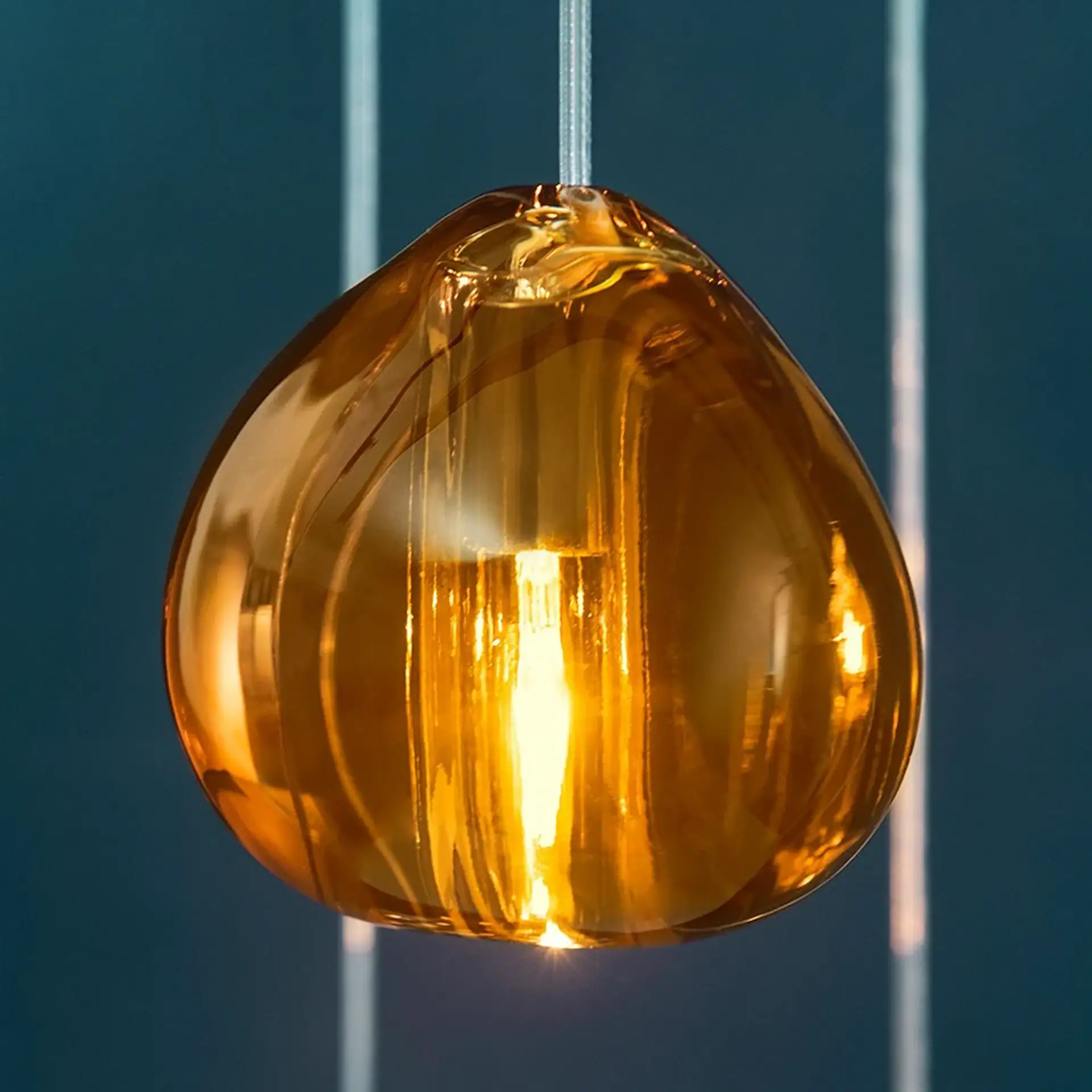 Elegant amber glass pendant light for contemporary home lighting.