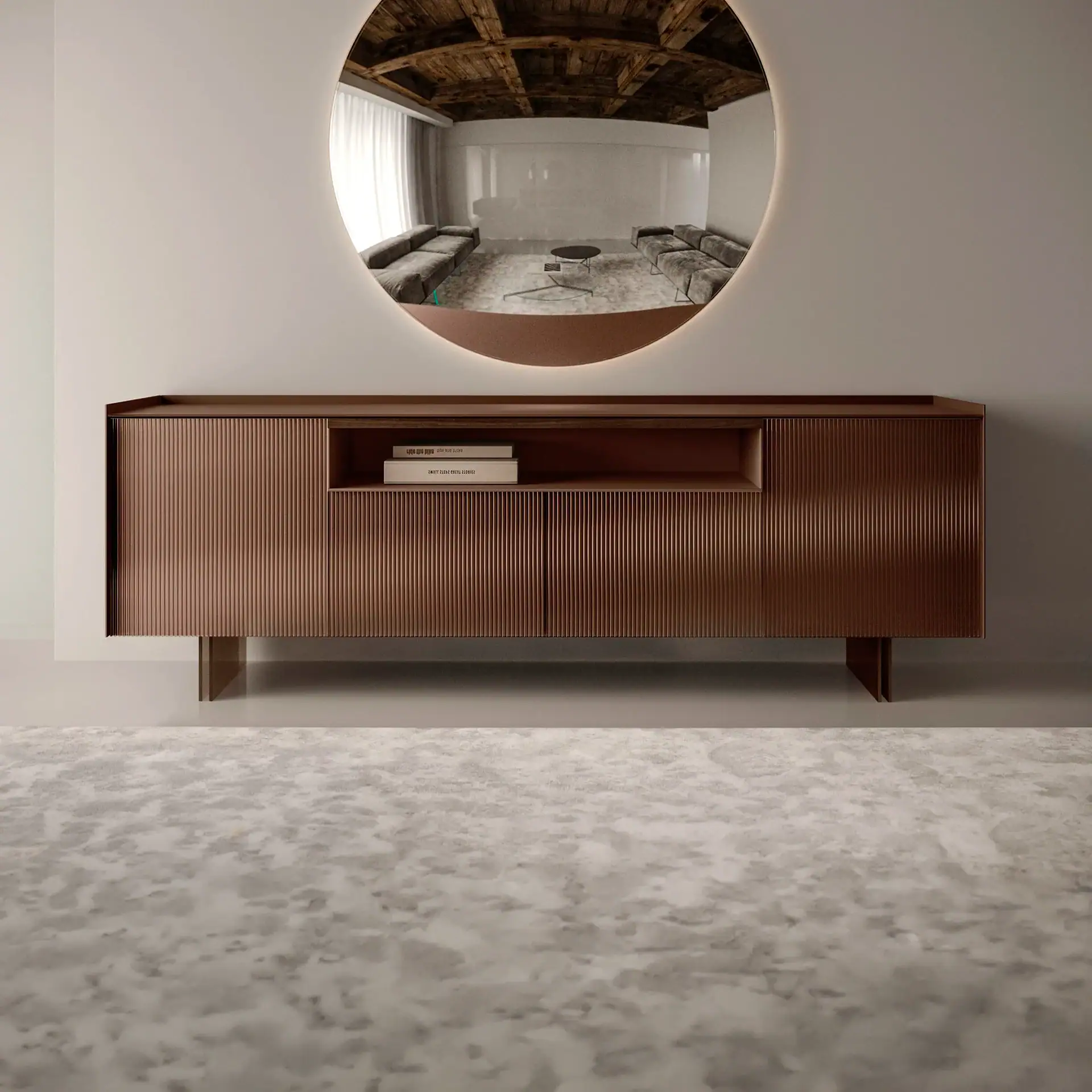 A modern bronze fluted sideboard with an open shelf sits below a large, backlit oval mirror reflecting a living room with two grey sofas and a coffee table.