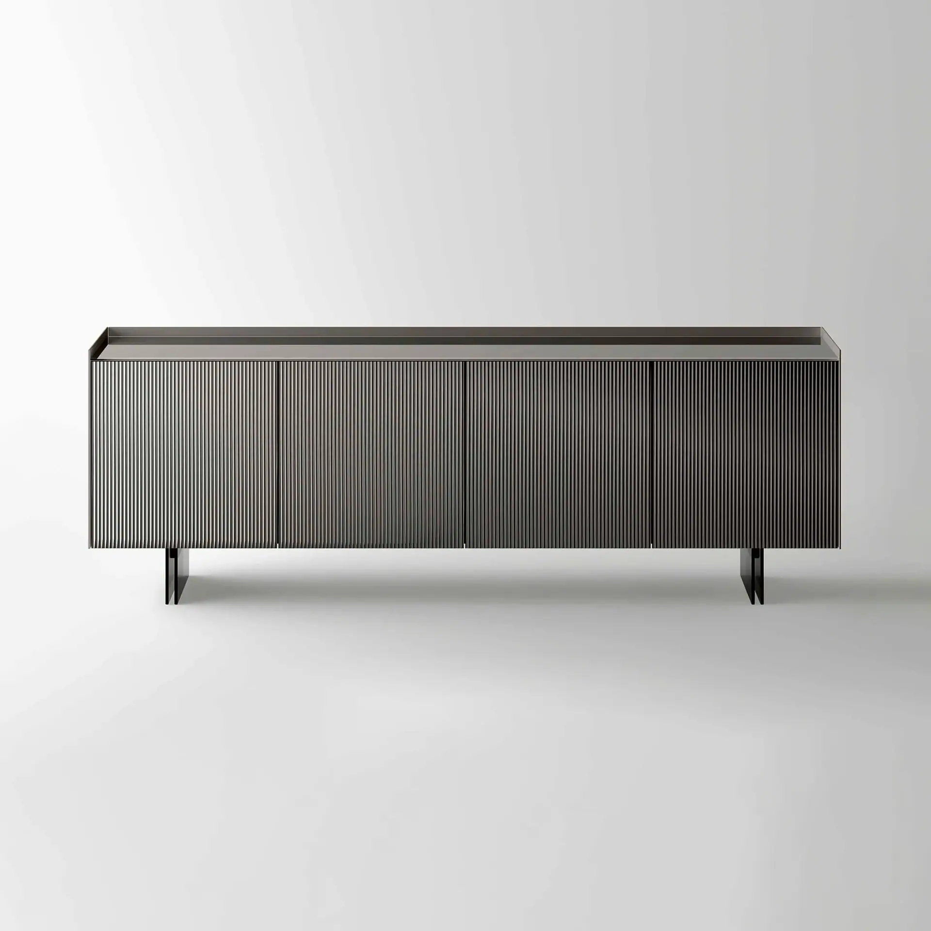 A dark, rectangular modern sideboard with vertical ribbed doors and minimalist legs against a white background.