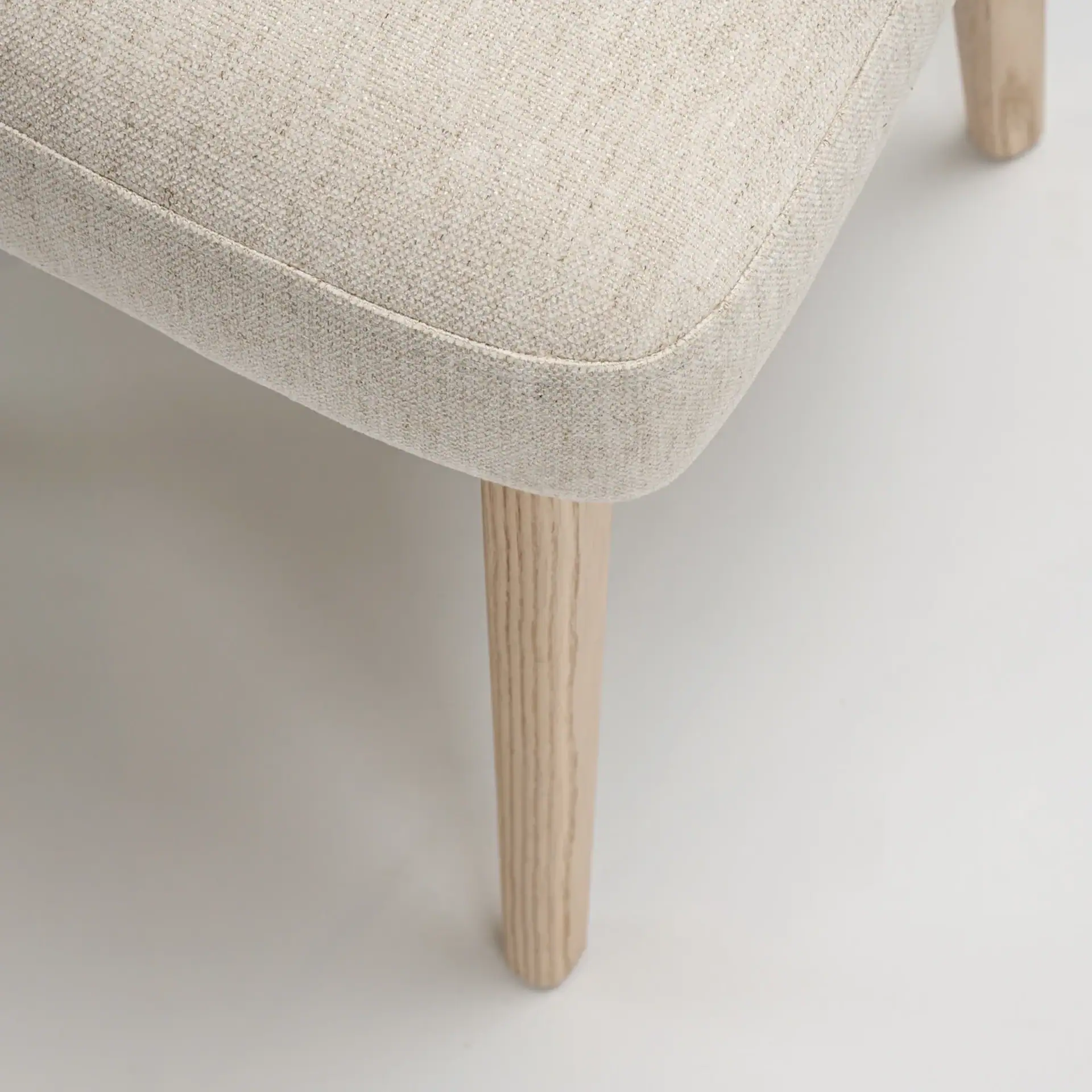 Close-up of the leg and fabric of the Tessa Upholstered Dining Armchair.