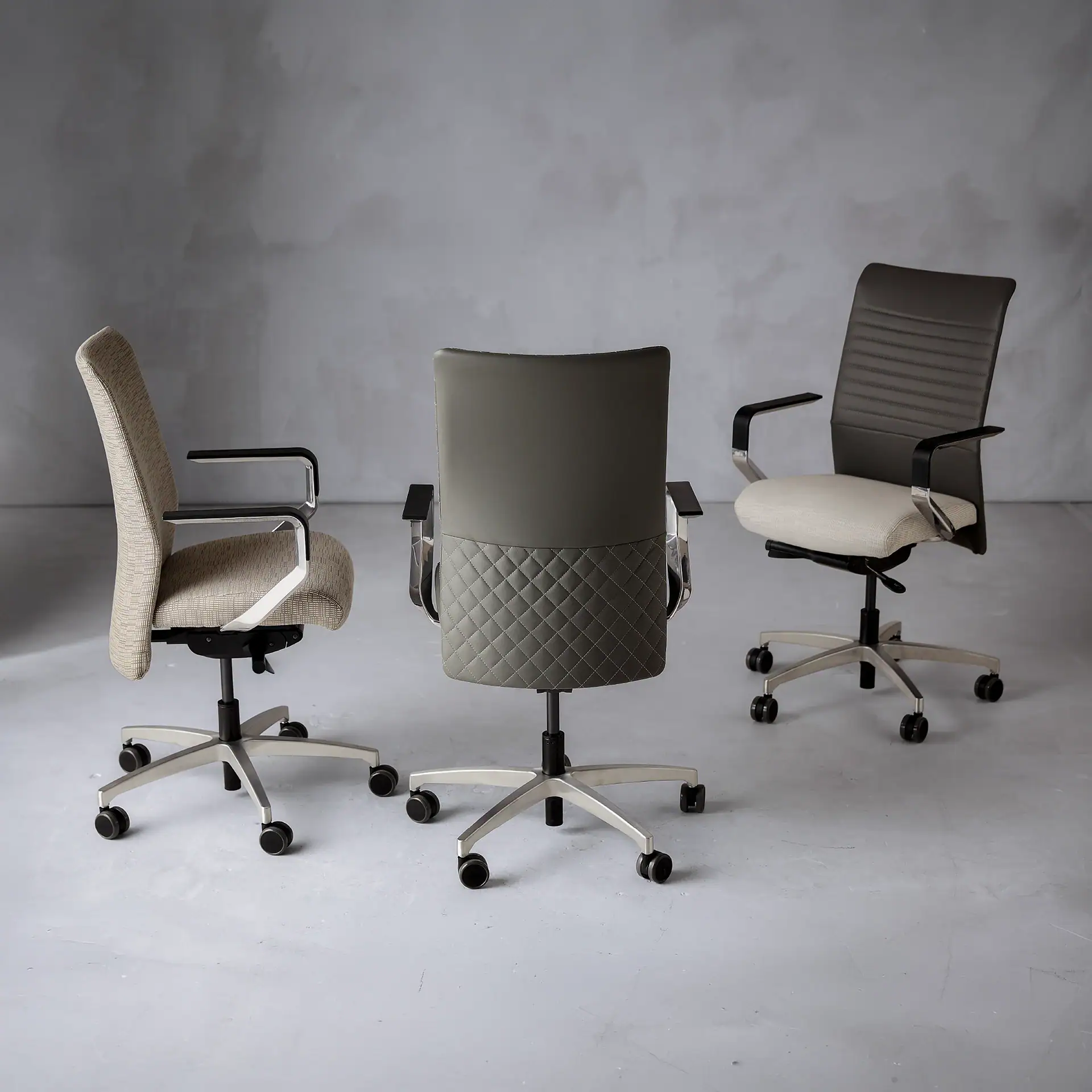 Three office chairs with different designs in a modern conference room.