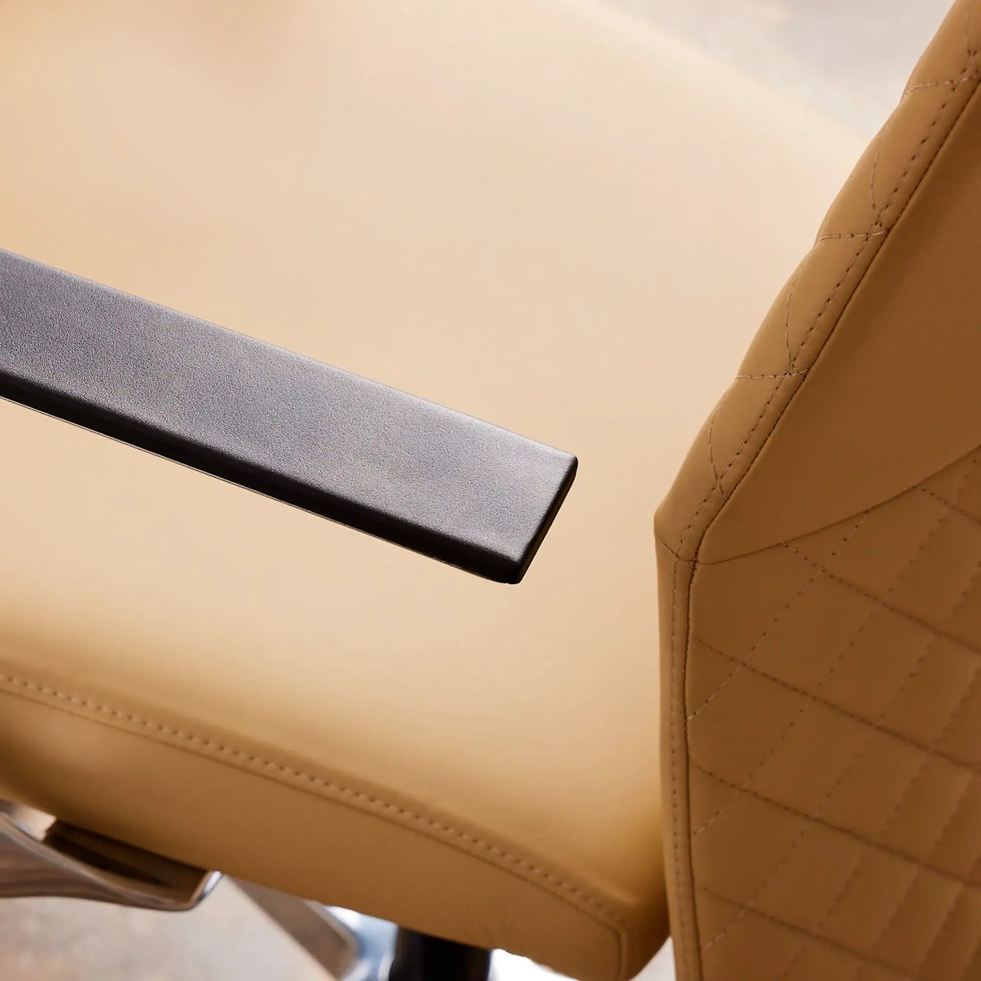 Close-up of beige Proform Office Chair with black armrest.