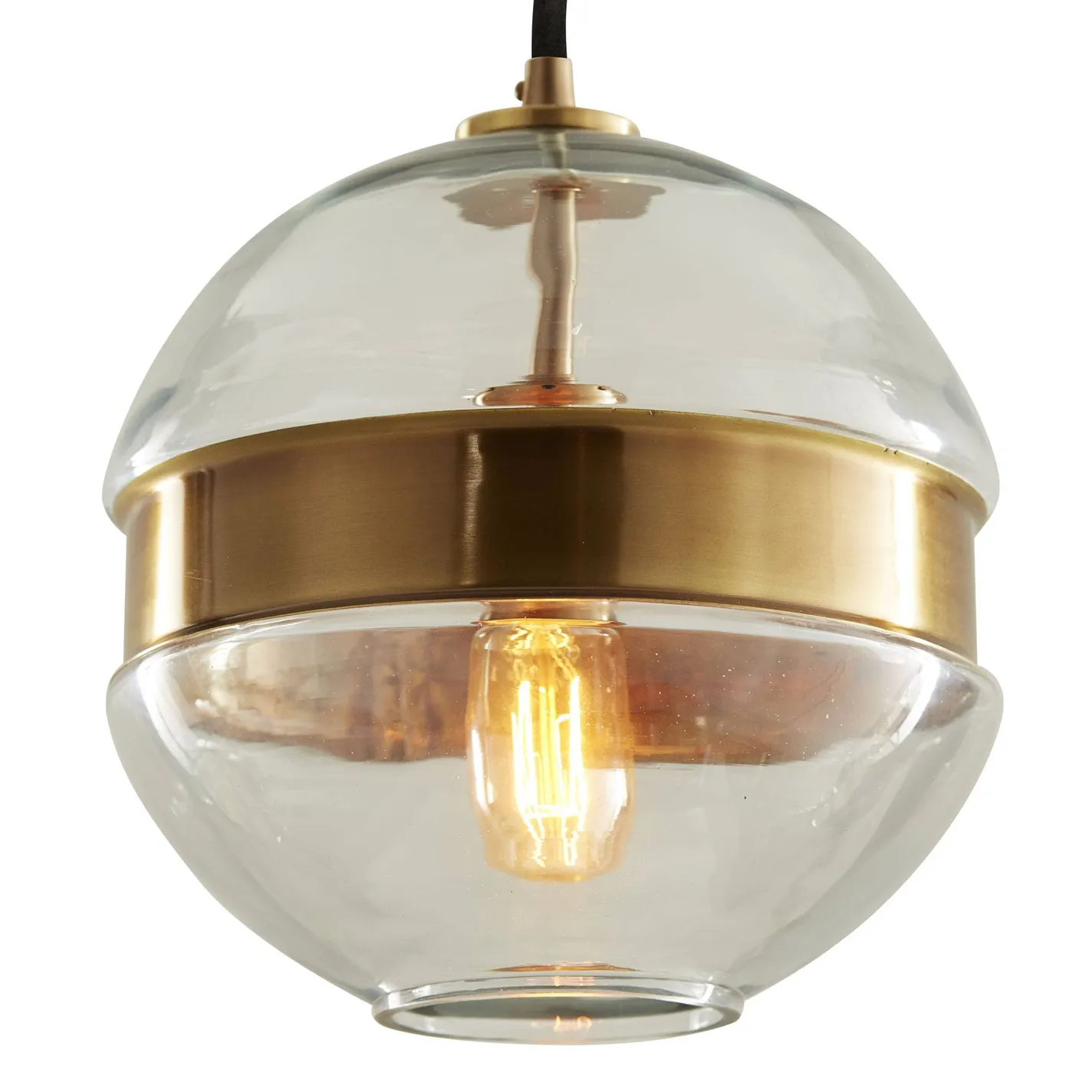 A modern pendant light fixture with clear glass domes and a central brushed brass band, illuminating a vintage-style Edison bulb.
