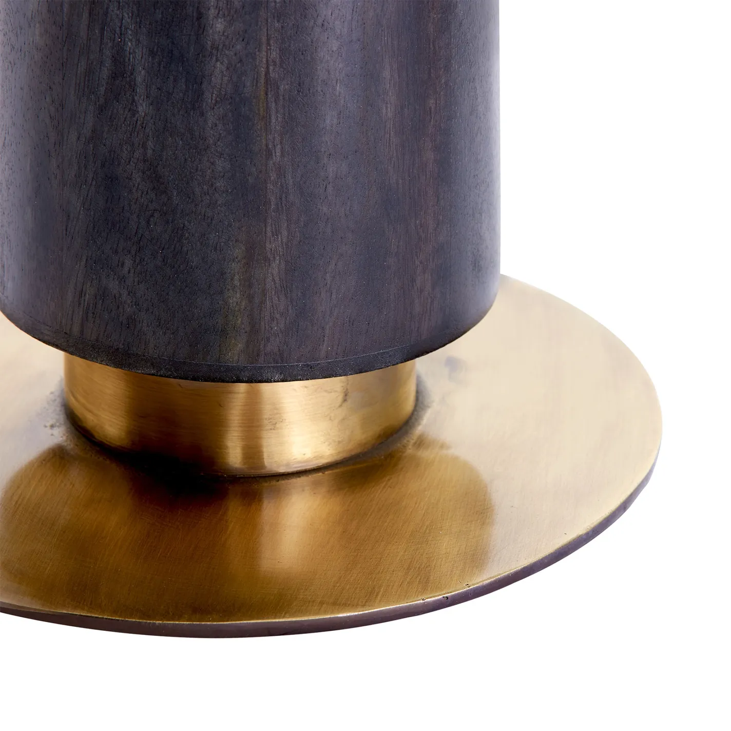 Close-up of a dark wooden column resting on a narrow brass ring, which in turn sits on a wider, flat, circular brass base. The background is white.