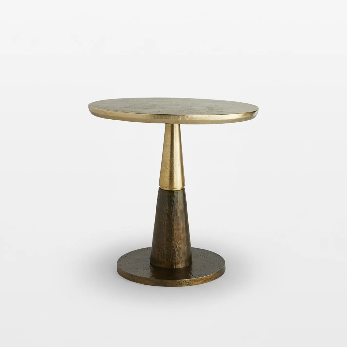 A modern side table with a round, aged brass top and a conical base made of dark wood or bronze.