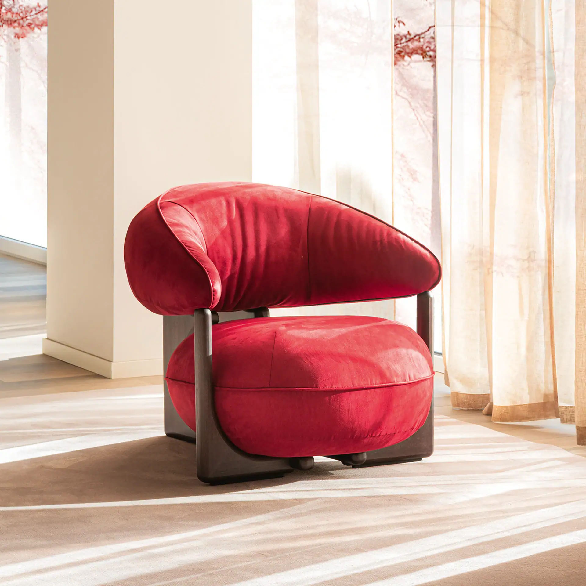 Luxurious red velvet lounge armchair with modern design.