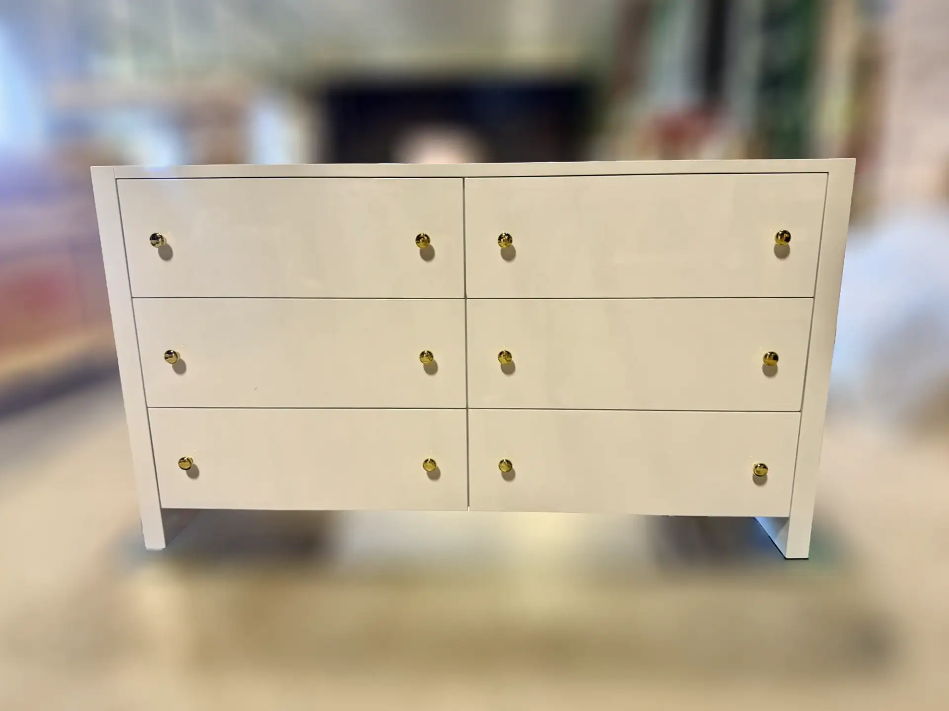 Elegant white 6-drawer dresser with gold knobs for bedroom decor.