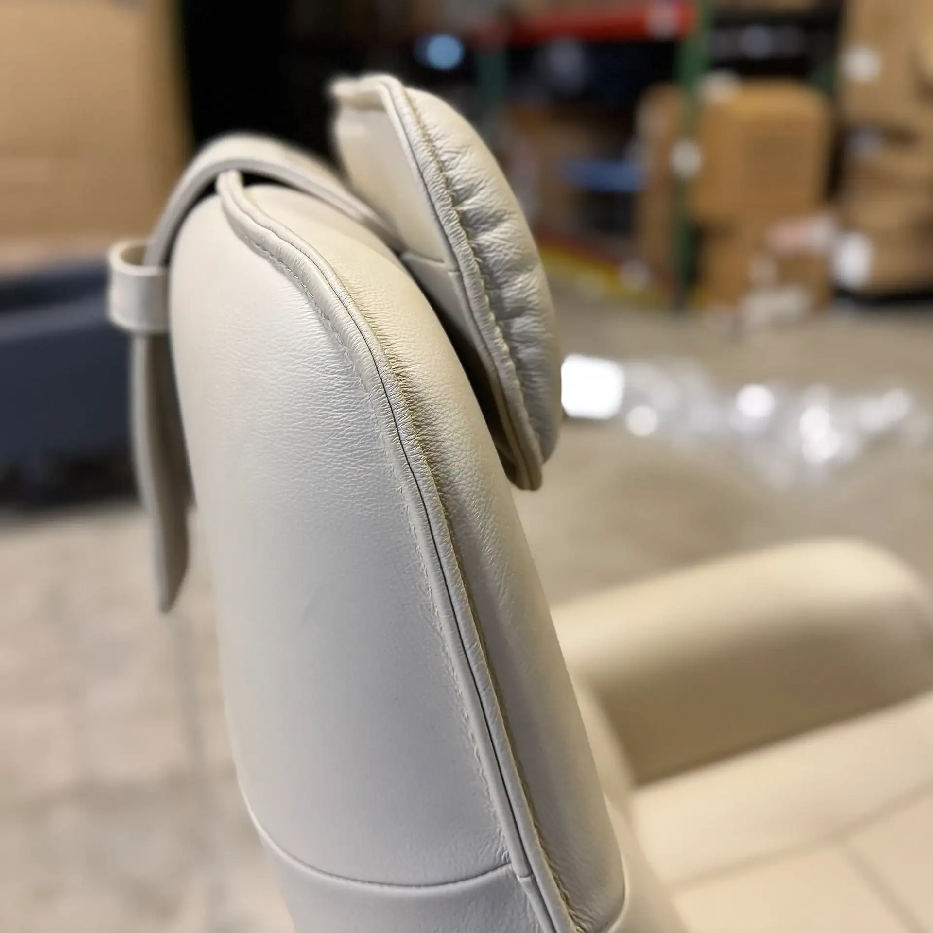 Close-up of a cream-colored recliner headrest with adjustable pillow.