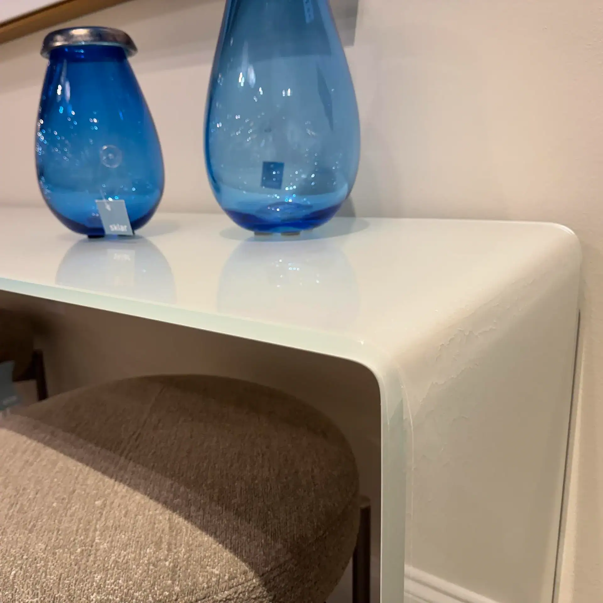 Glassisimo Grampo console table with blue glass vases on top.