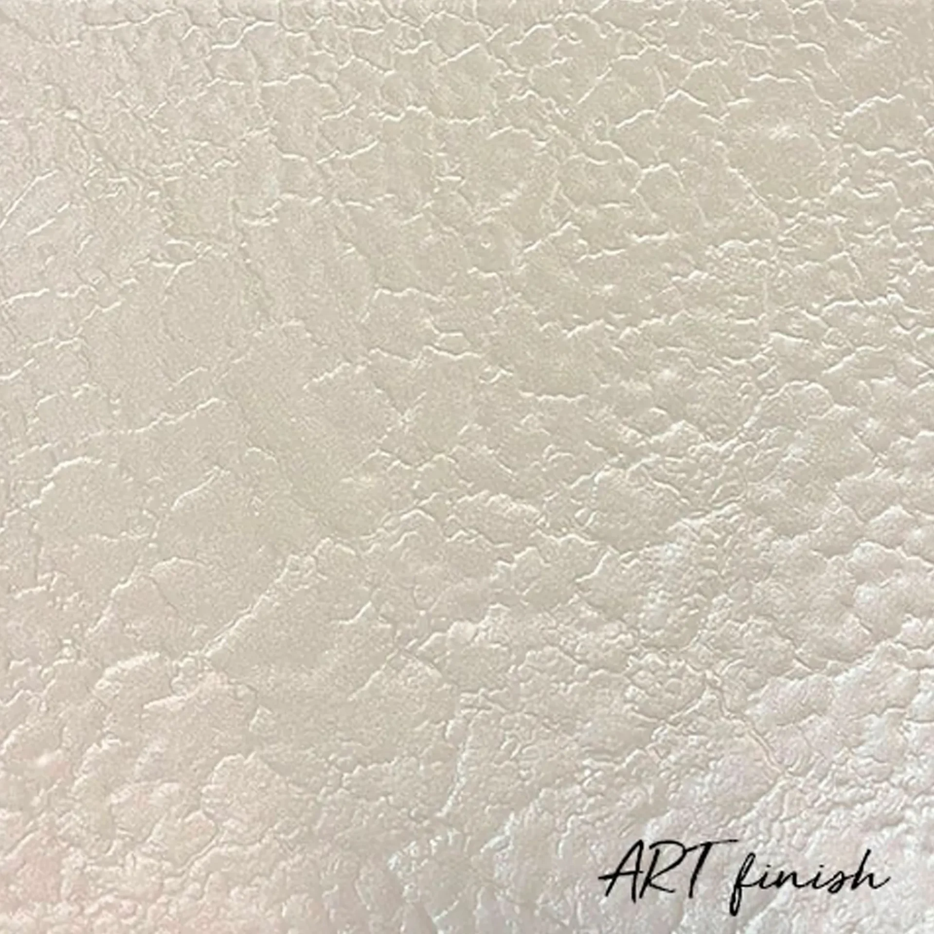 Close-up of a textured off-white surface with an irregular, cracked pattern and "ART finish" written in cursive.