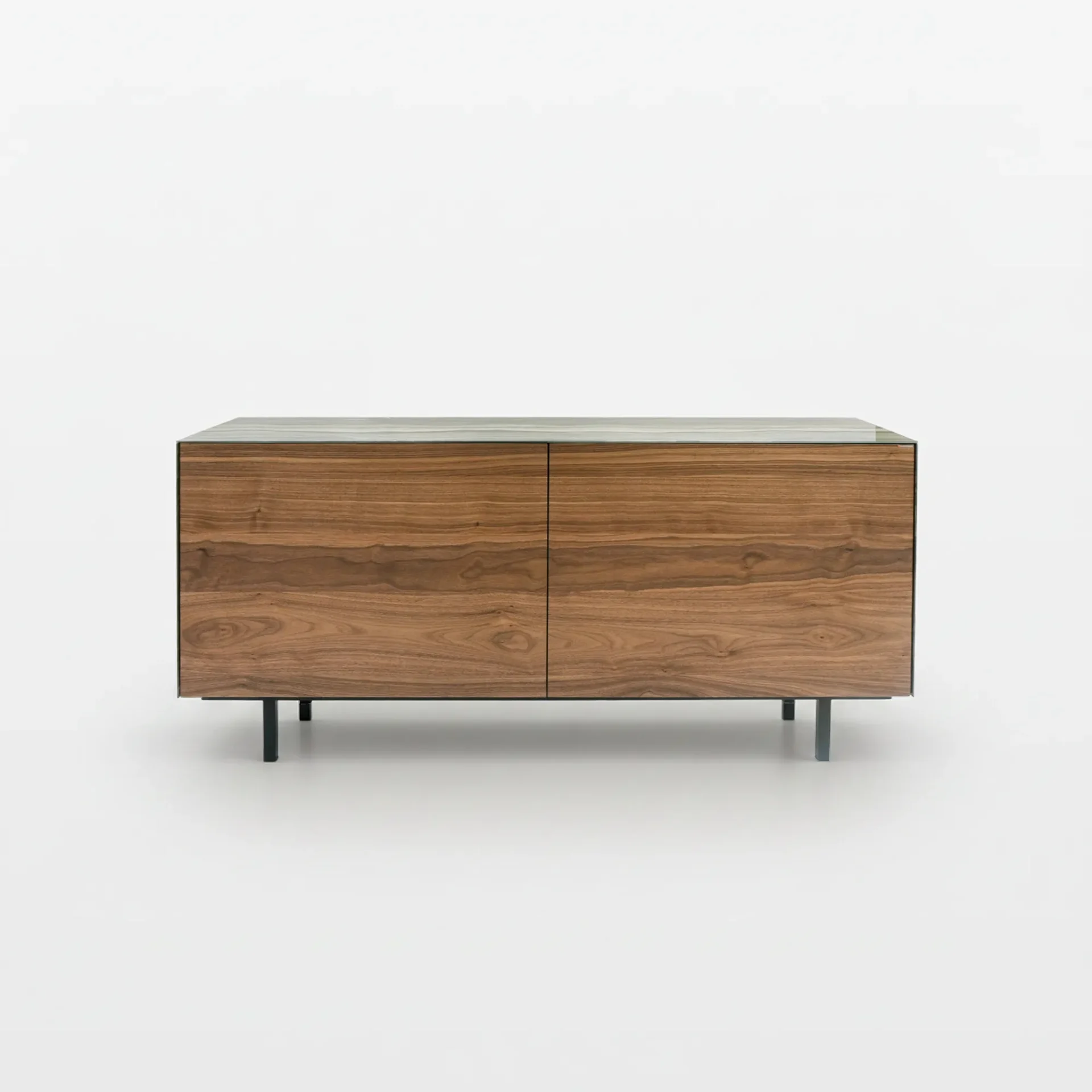 A modern, rectangular wooden cabinet with two doors, a light-colored top, and thin dark metal legs, against a white background.