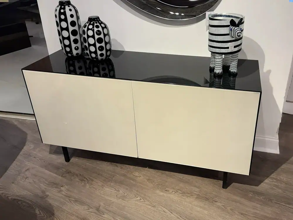 Modern black and white buffet with decorative vases and plush toy.