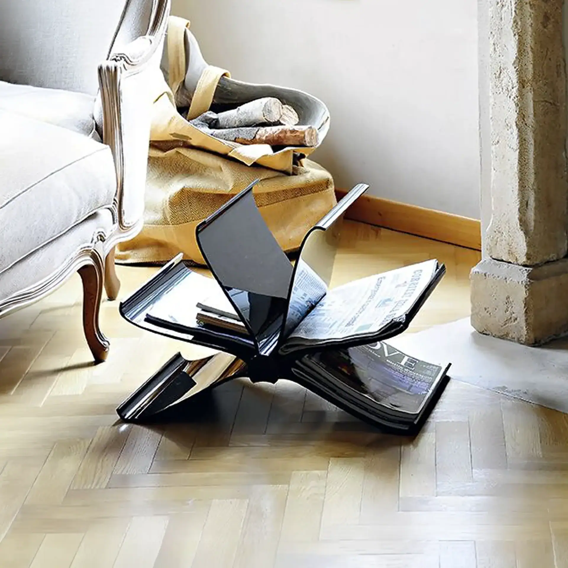 Modern black magazine rack with open compartments on wooden floor.