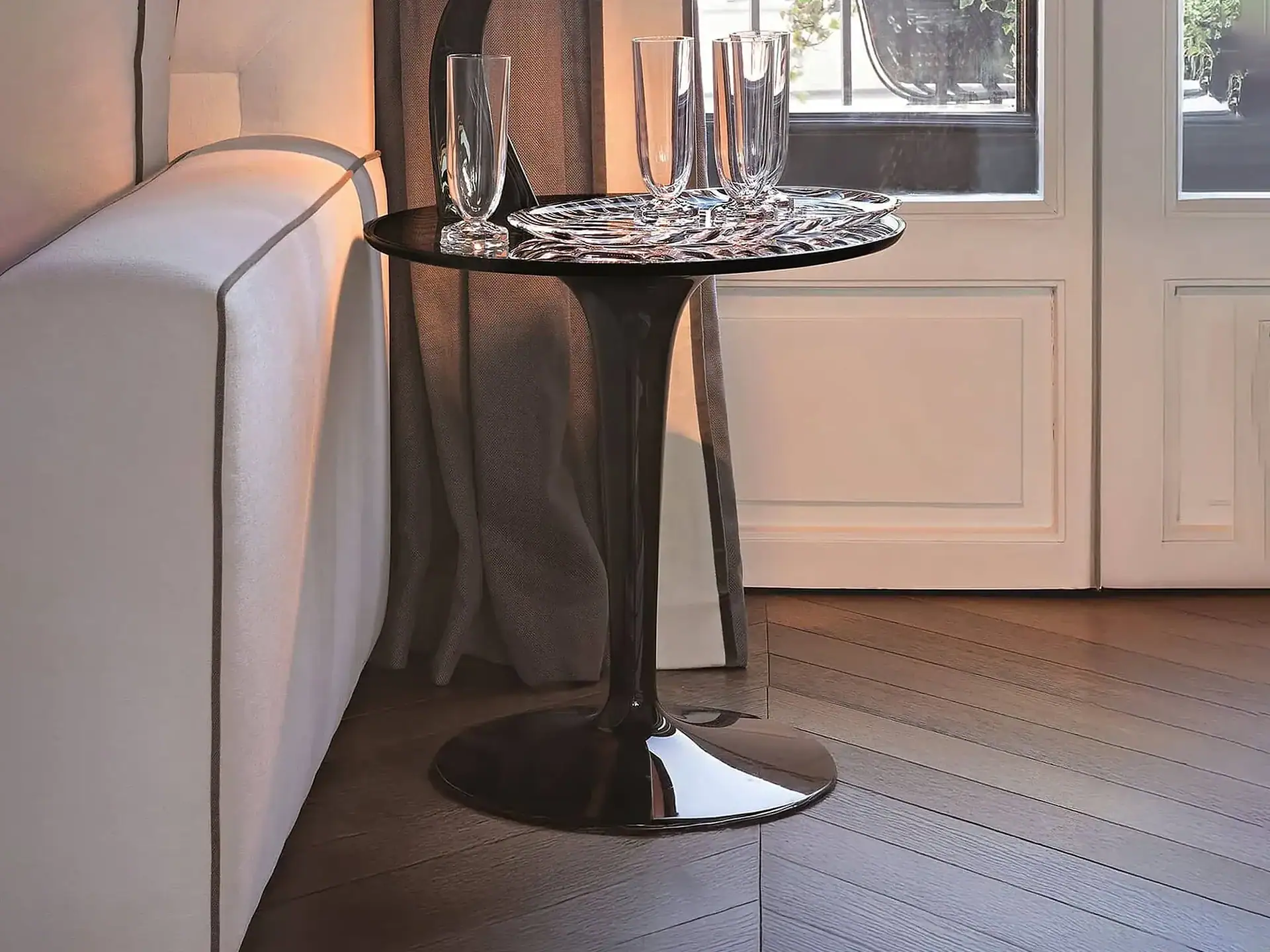 Stylish Kartell TipTop side table with glassware, ideal for contemporary interiors.