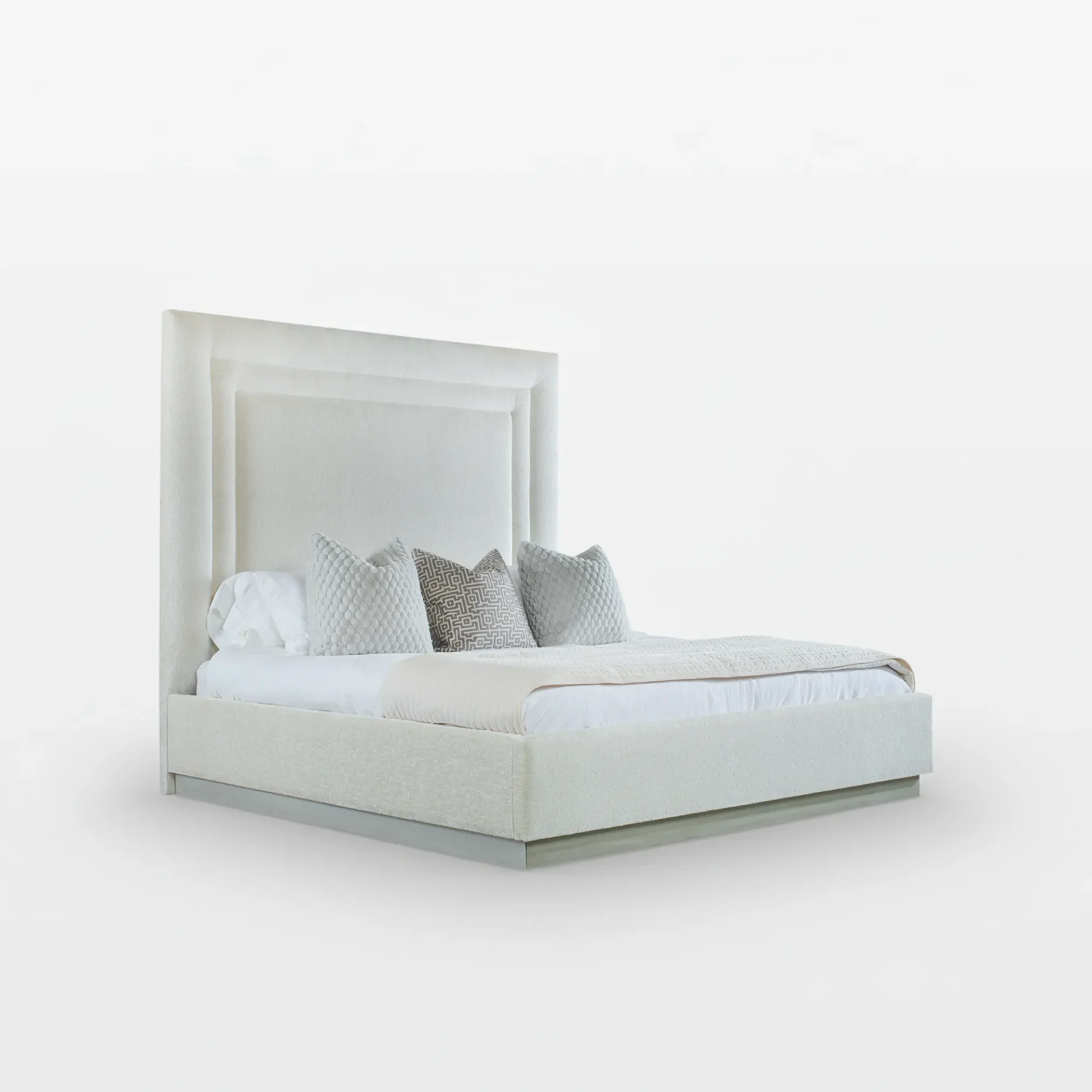 A modern, off-white upholstered platform bed with a tall, paneled headboard, white bedding, and three decorative pillows.