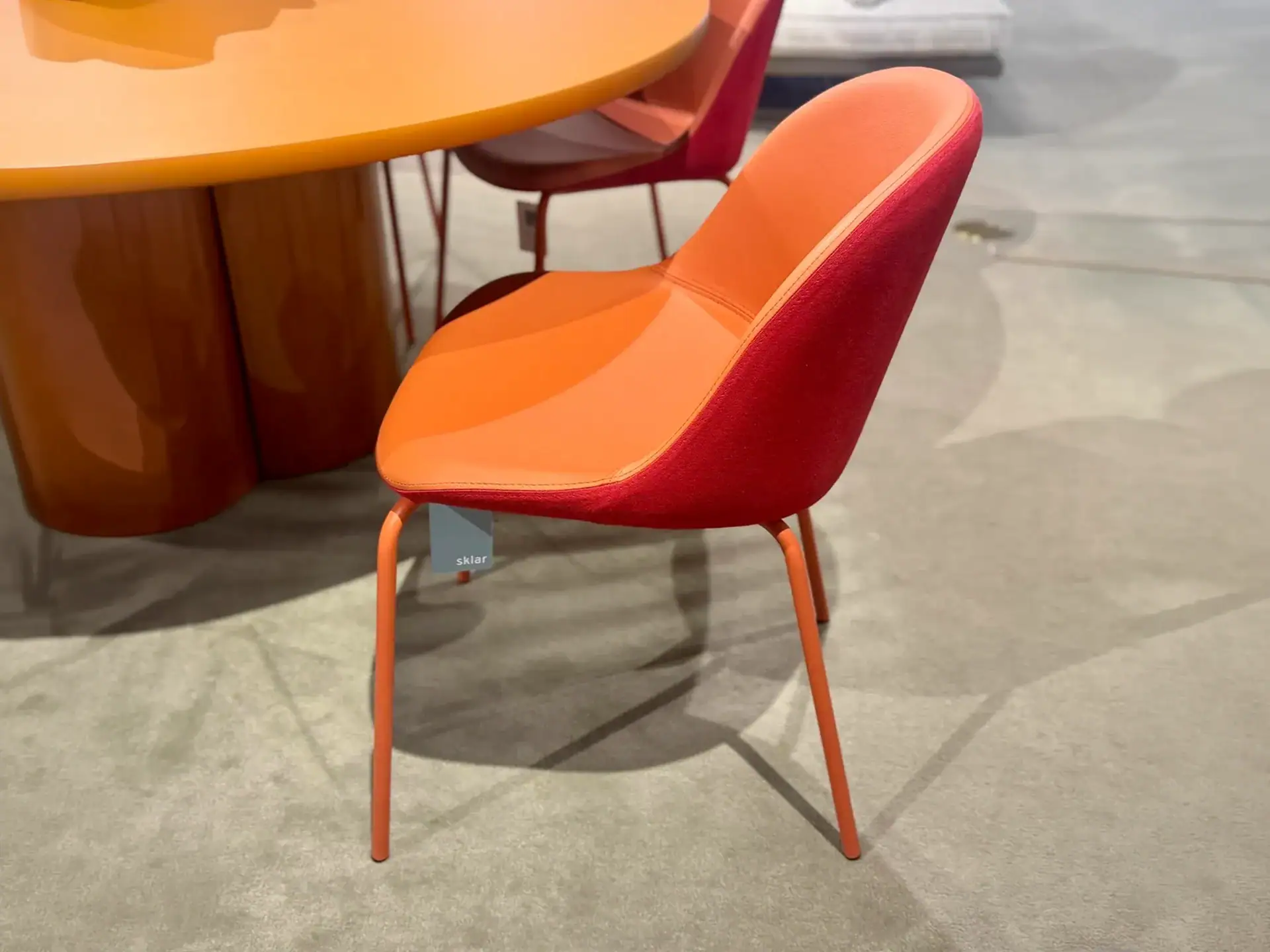 Colorful upholstered dining chair with orange and red fabric.