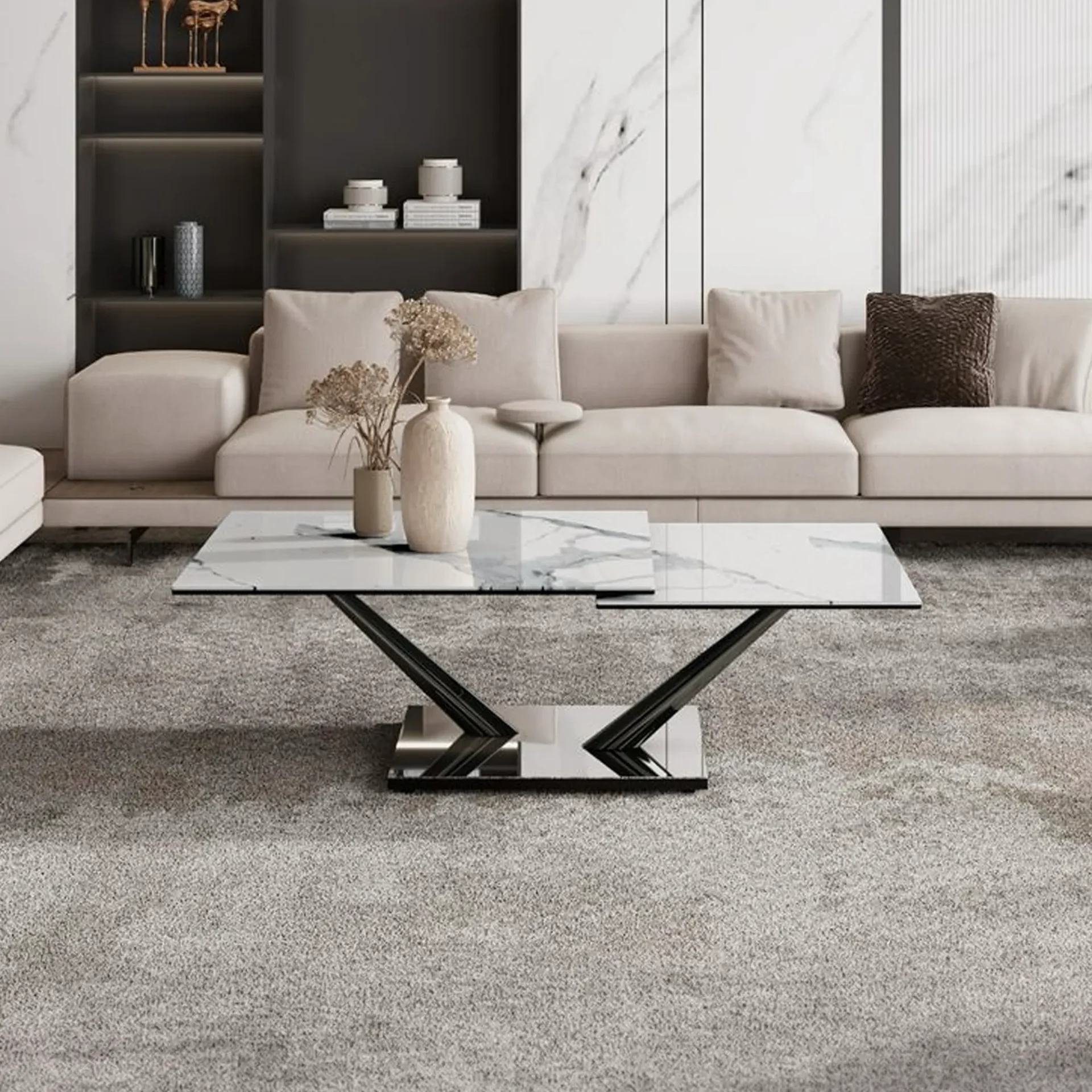 A modern living room with a light beige sectional sofa, a white marble-patterned coffee table with a geometric base, and a gray rug. Decorative vases are on the table, and a dark gray shelving unit with decor is in the background.