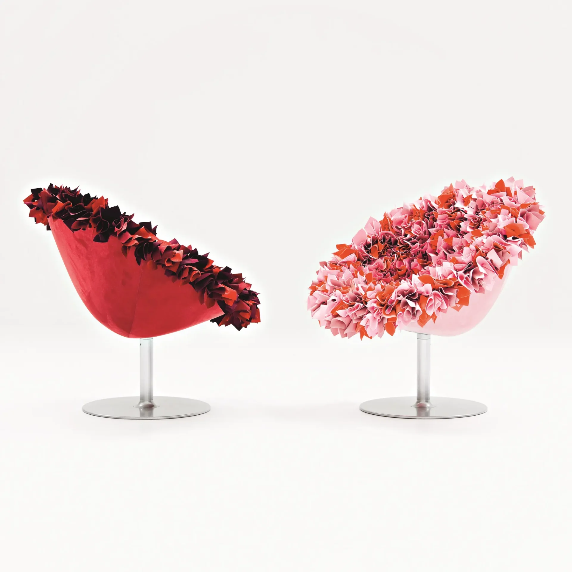Two modern bucket chairs with ruffled fabric interiors, one red and one pink, on a white background.