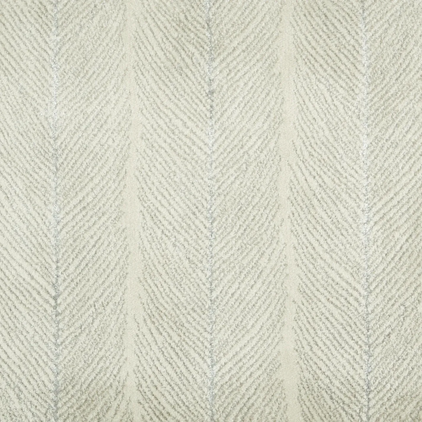 Close-up of a textured cream and light grey chevron pattern textile, resembling a soft carpet or fabric.