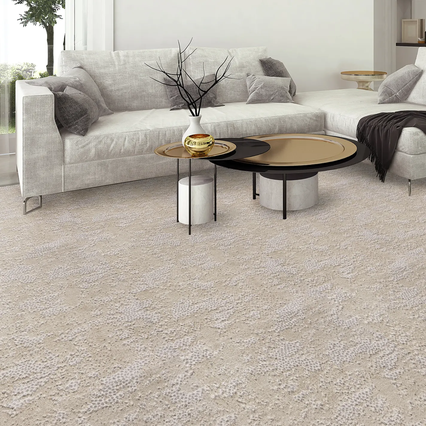 A modern living room with a light grey sectional sofa, two contemporary coffee tables with gold accents, and a textured beige carpet covering the floor.