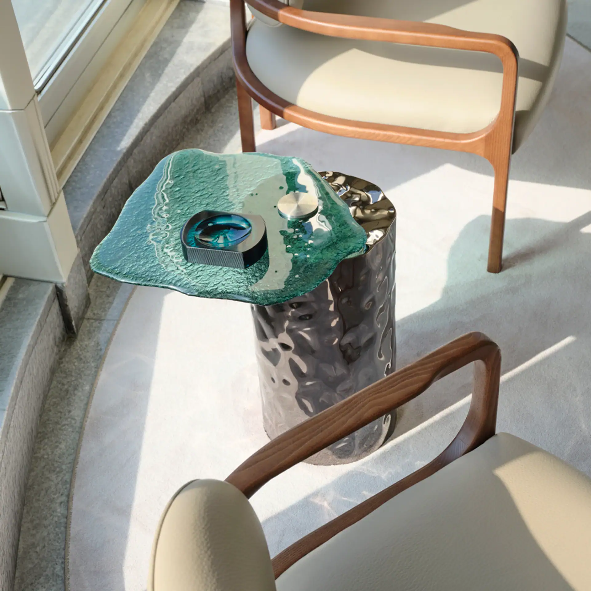 Modern Materia coffee table with textured black base and glass top in living room setting.