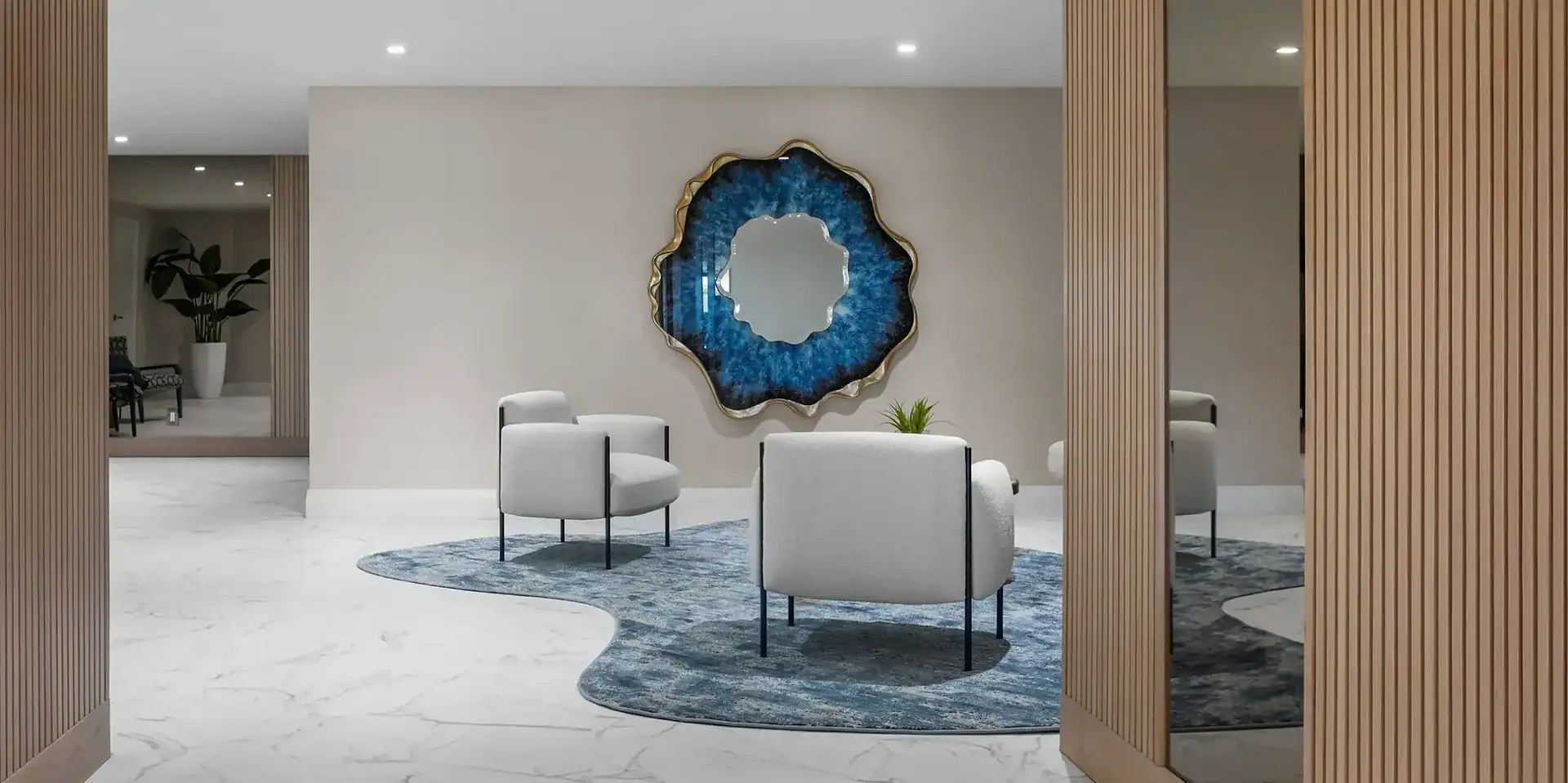 Elegant lobby seating area with white chairs and blue accent wall, stylish and comfortable for visit.