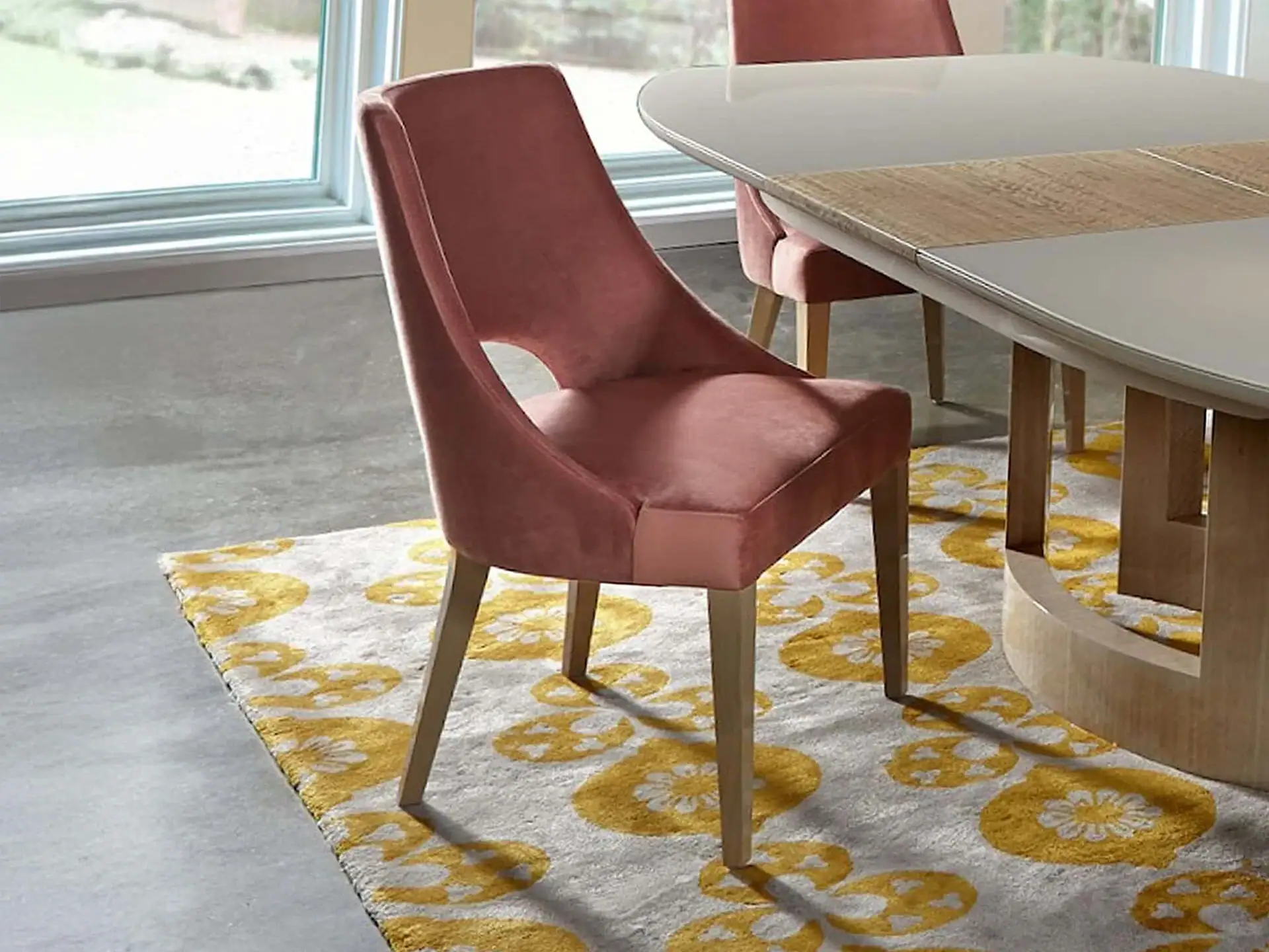 Pink upholstered dining chair with wooden legs, stylish and comfortable for modern dining rooms.