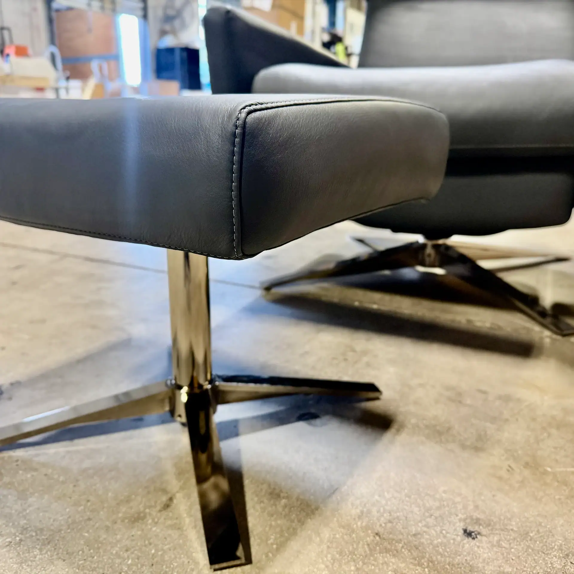 Close-up of the modern leather chair and ottoman with metal base.