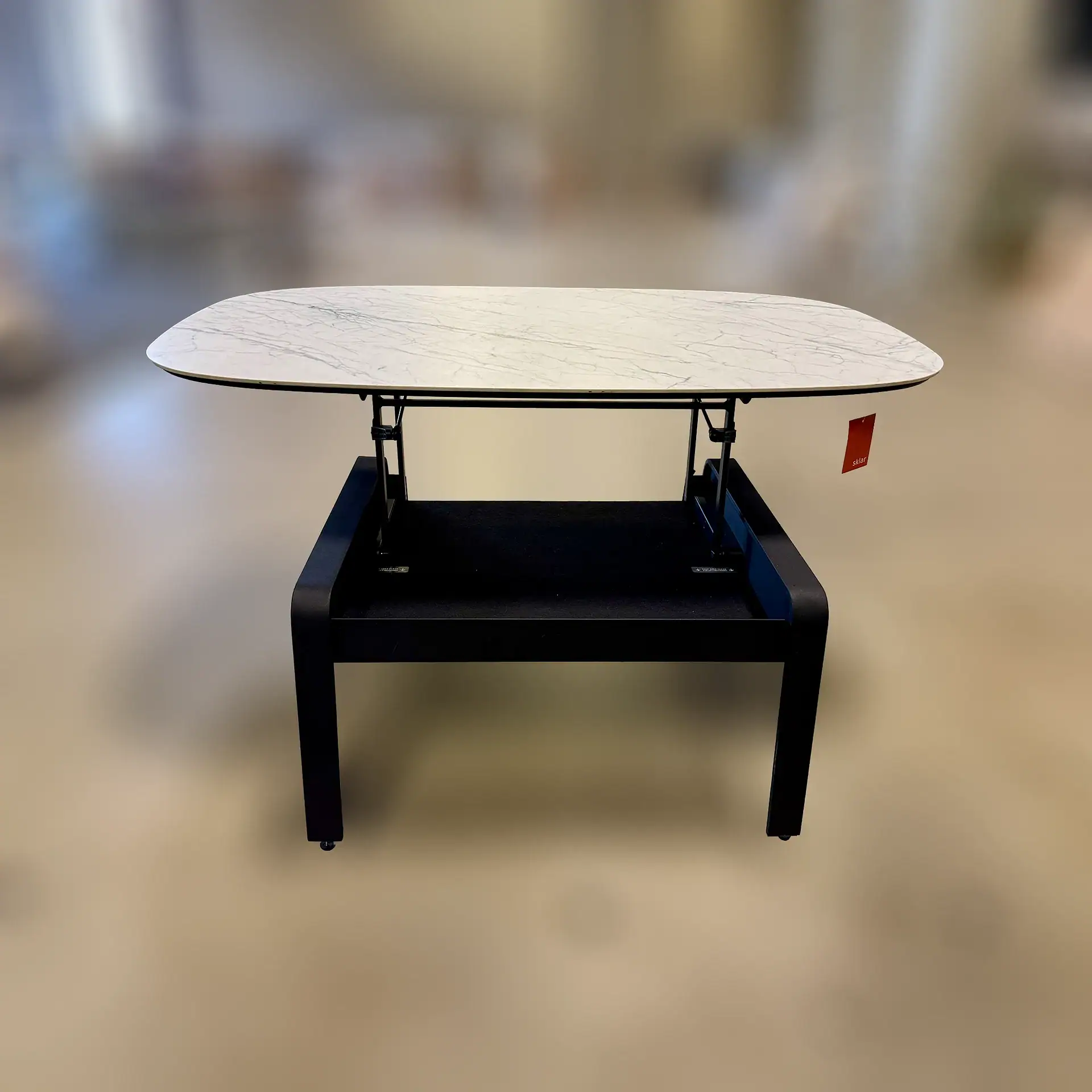 Modern lift coffee table with marble top and black base.