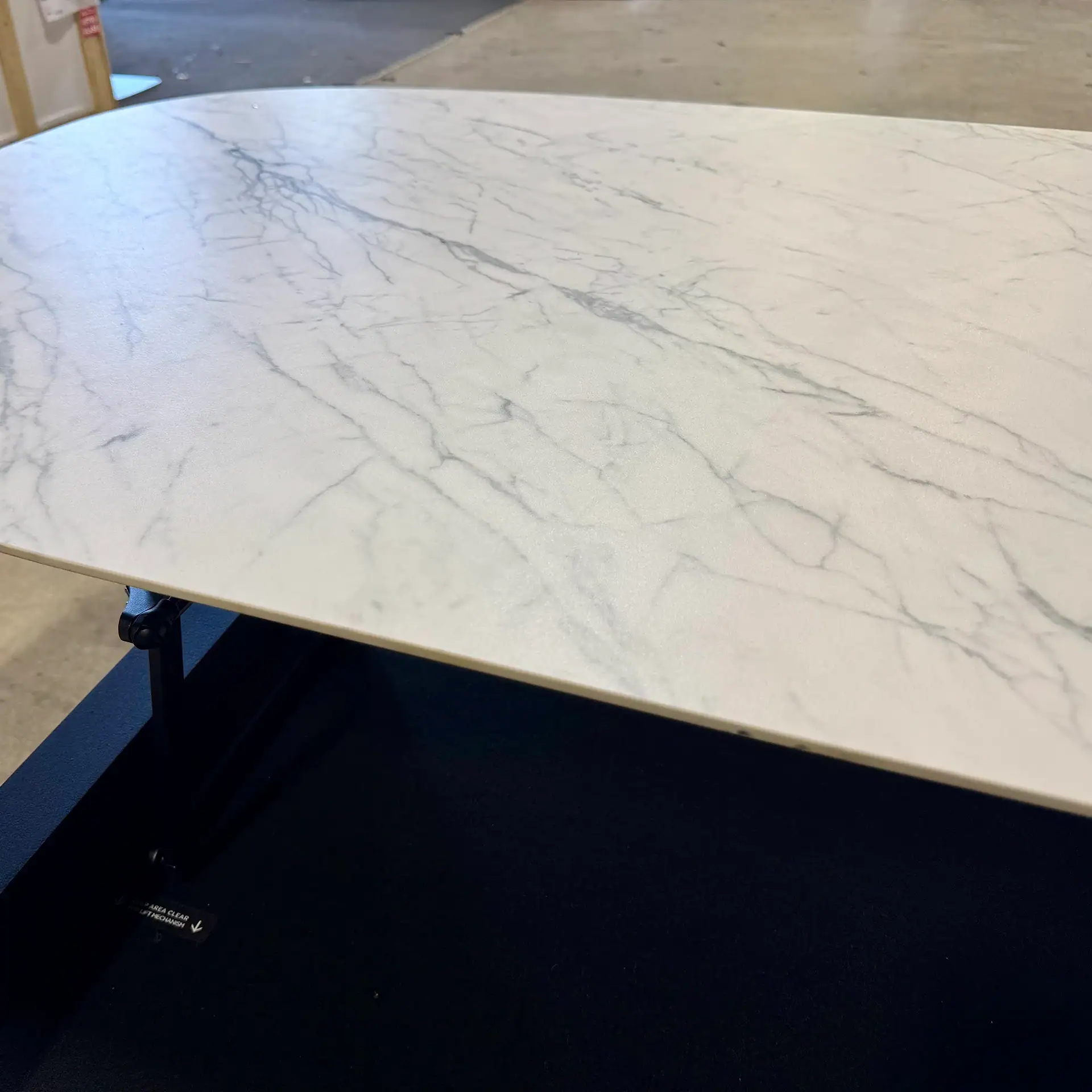 White marble lift coffee table with black base in modern style.