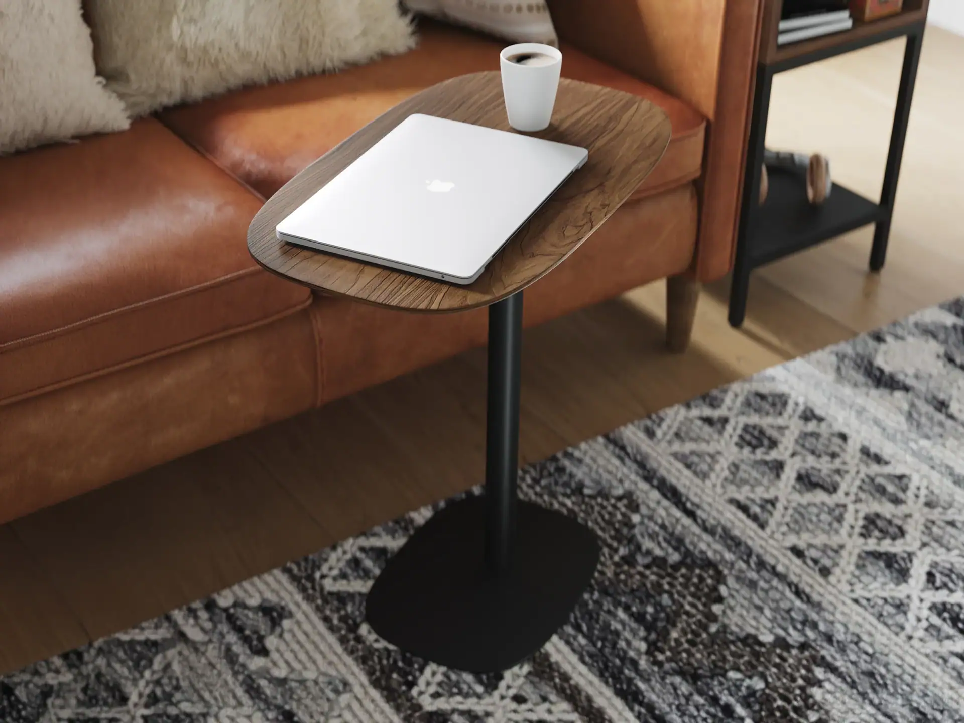 Laptop and coffee cup on BDI Serif Lift Laptop Table in modern living room.