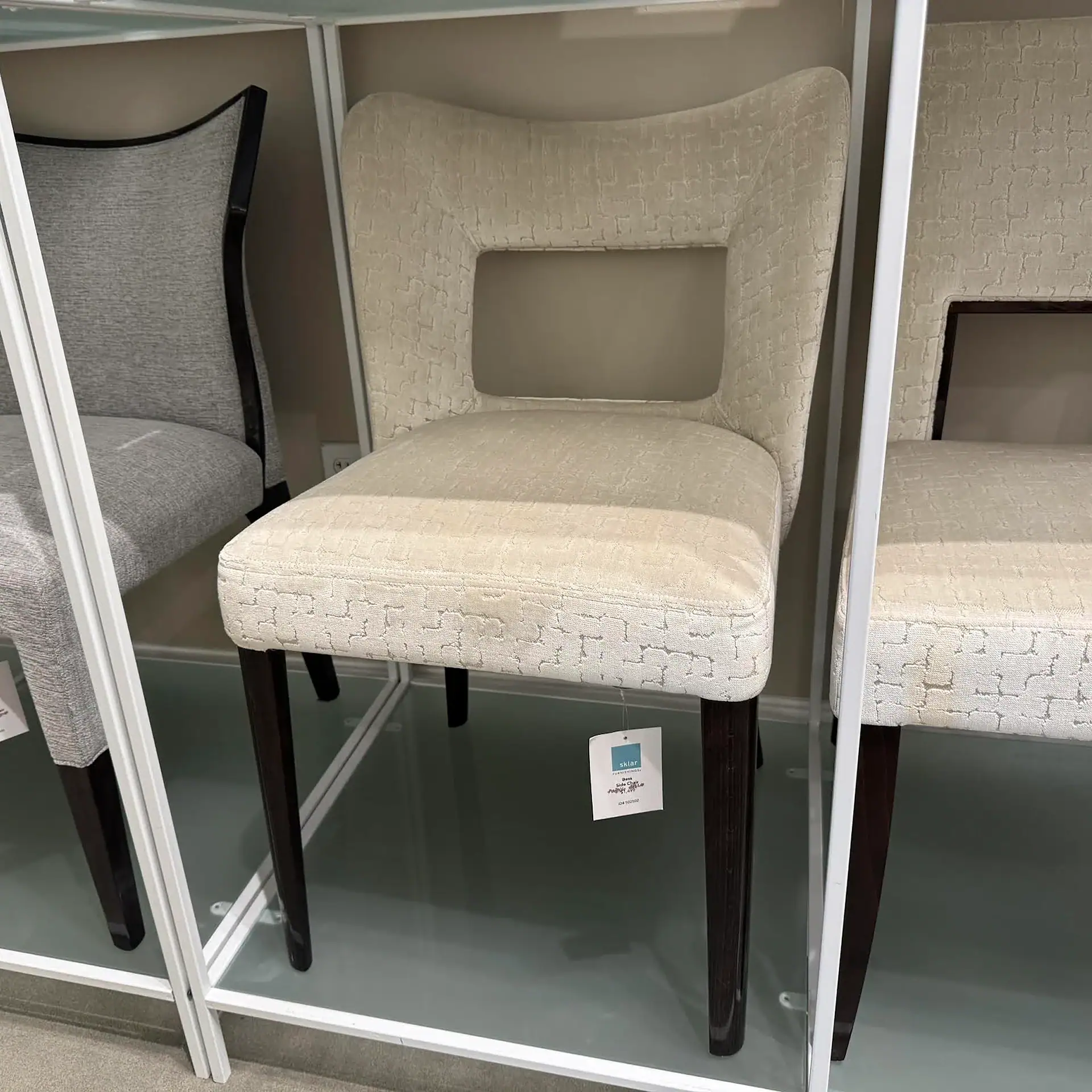 Accent chair with beige fabric upholstery and dark wooden legs, ideal for living rooms or offices.