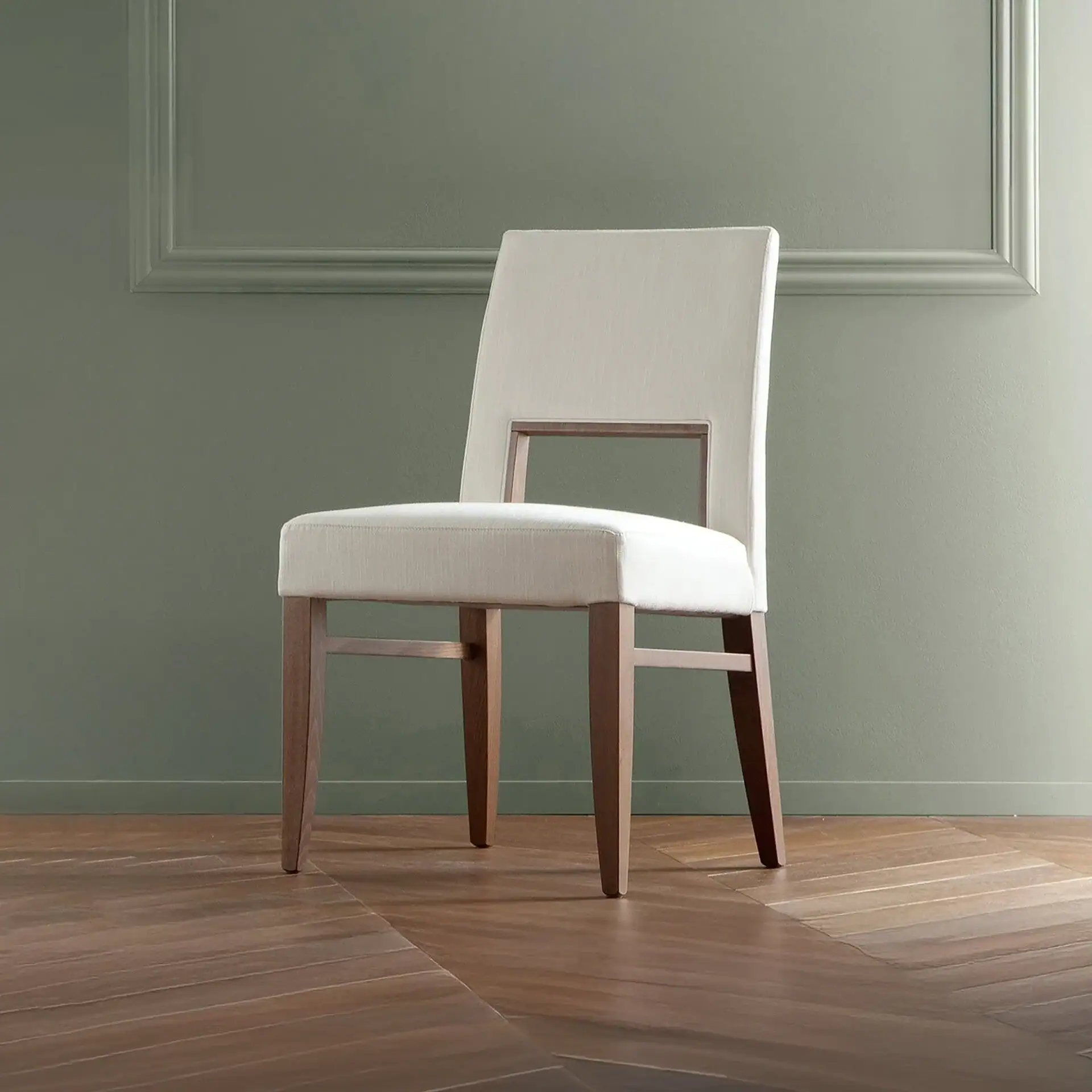 White upholstered dining chair with wooden legs in a modern interior setting.