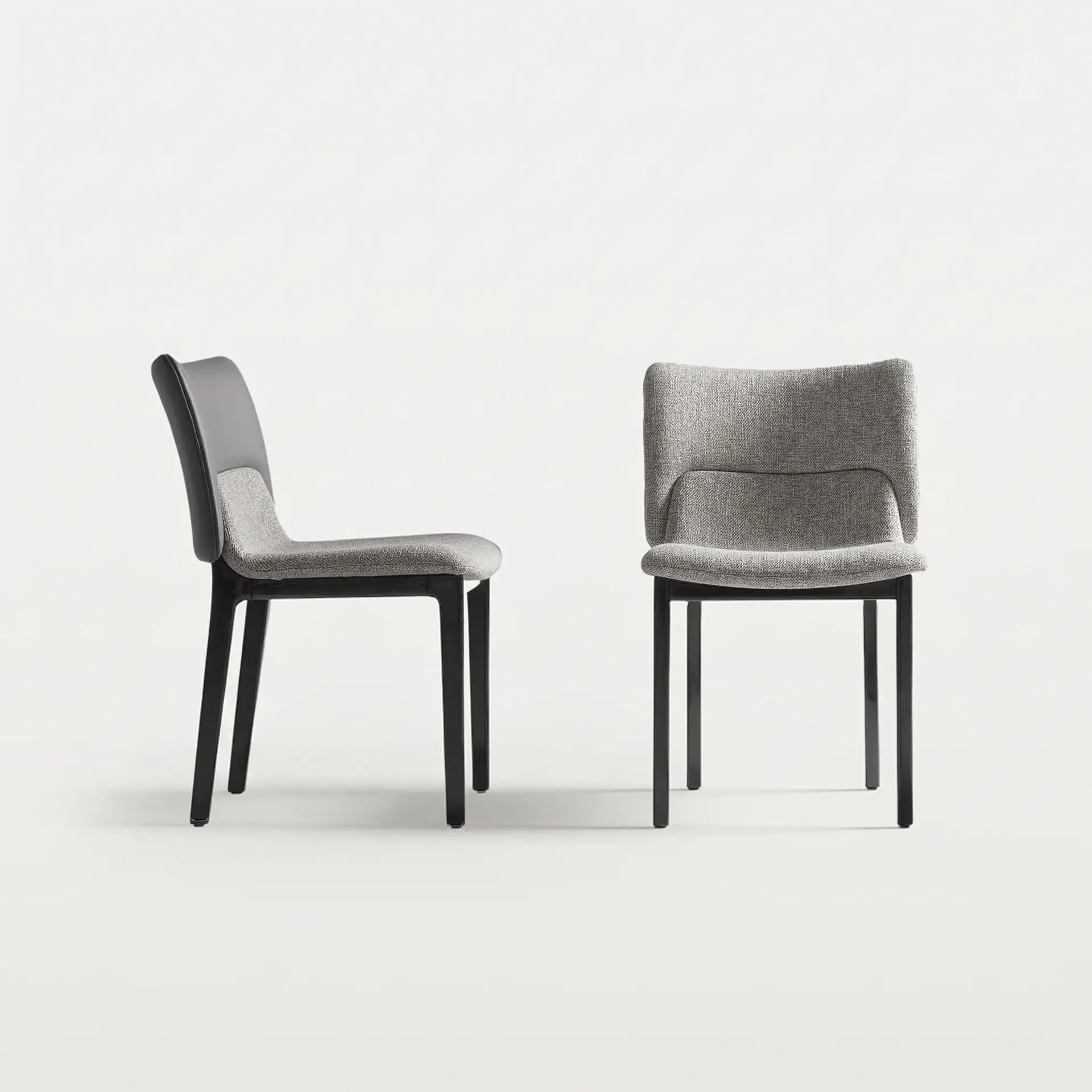 Modern grey upholstered side dining chair with black wooden legs.