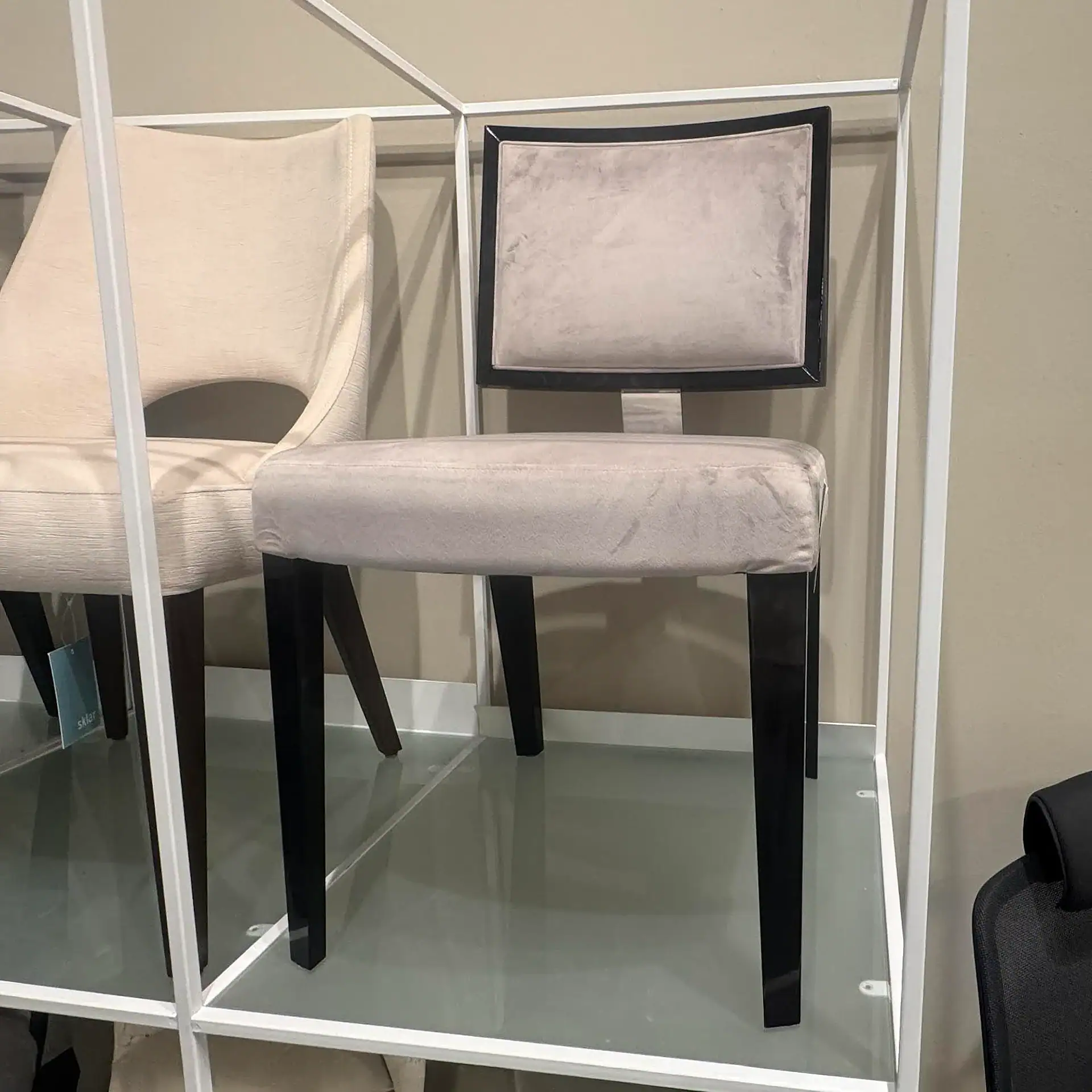 Upholstered dining chair with beige fabric and black wooden legs, ideal for contemporary dining room.