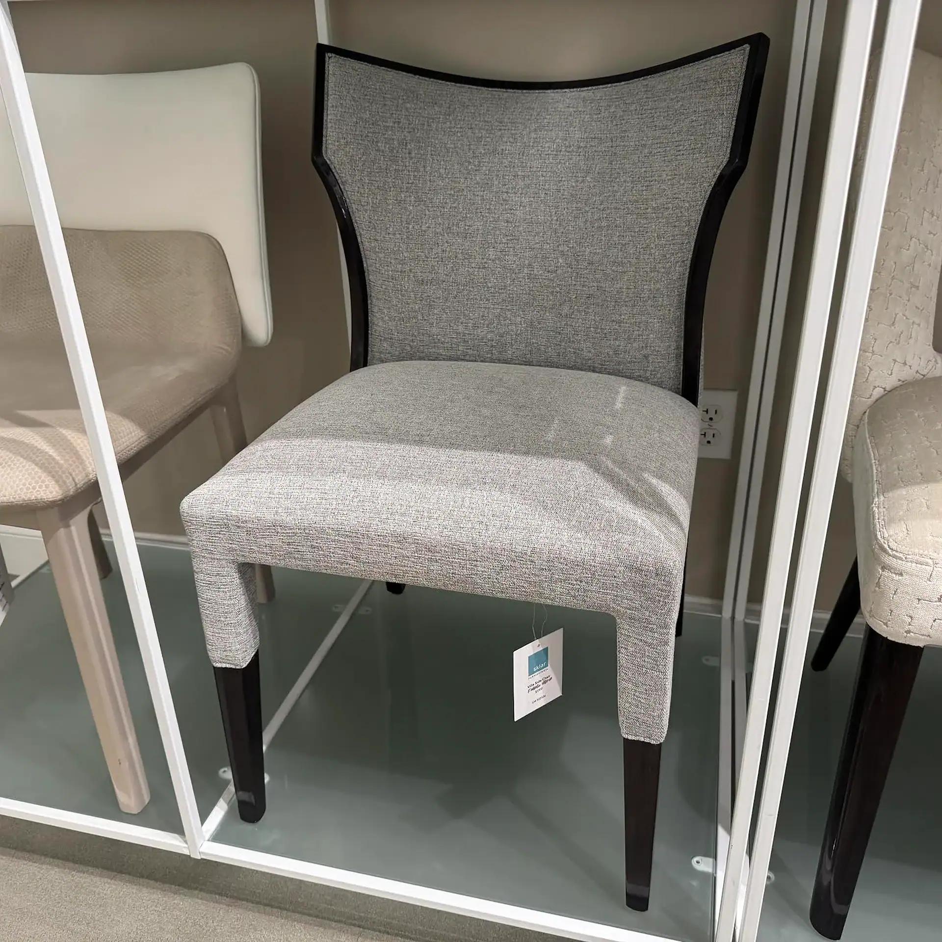 Stylish grey upholstered accent chair with black legs, perfect for living room decor.