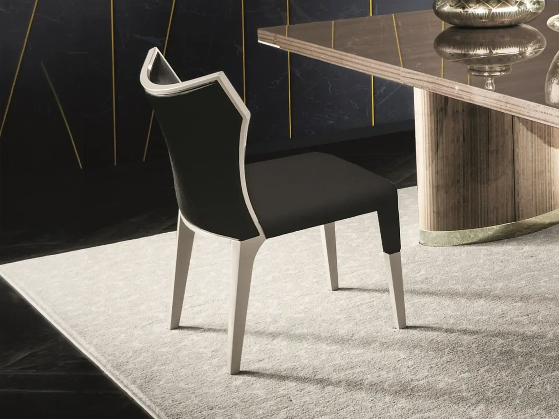 Modern black and white dining chair with sleek design and armrest detail.