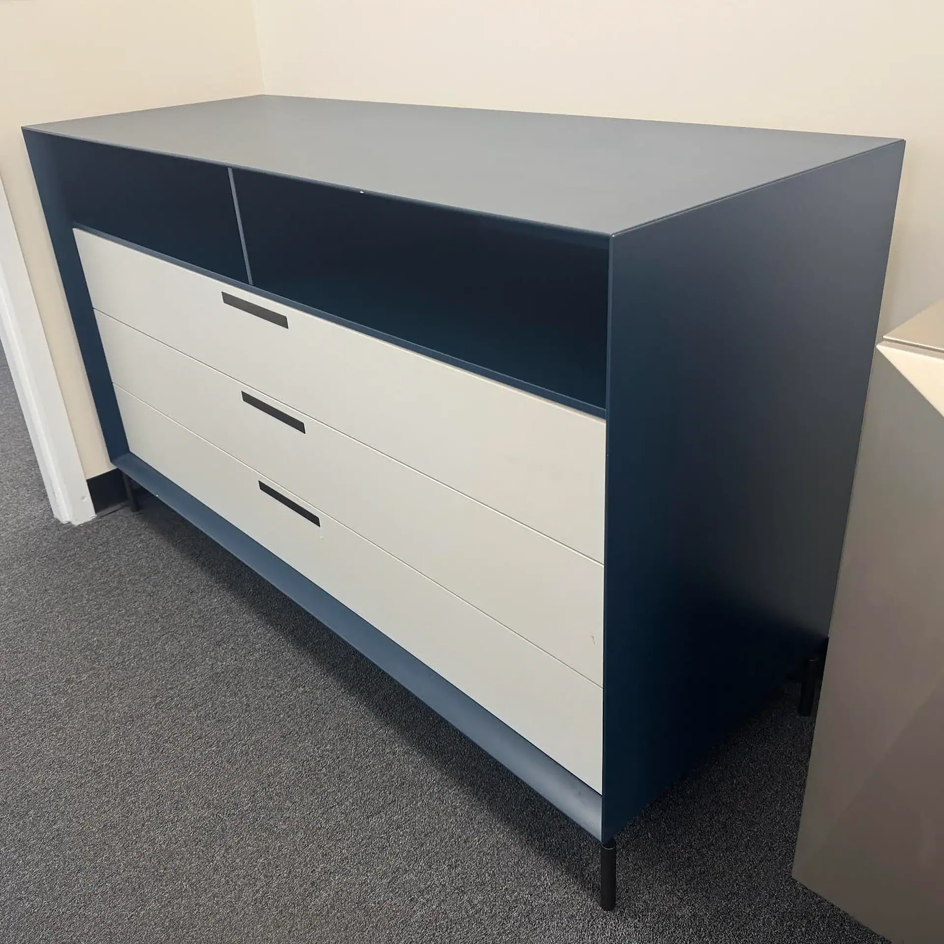 Navy and white modern dresser with open shelf and three drawers for bedroom storage.