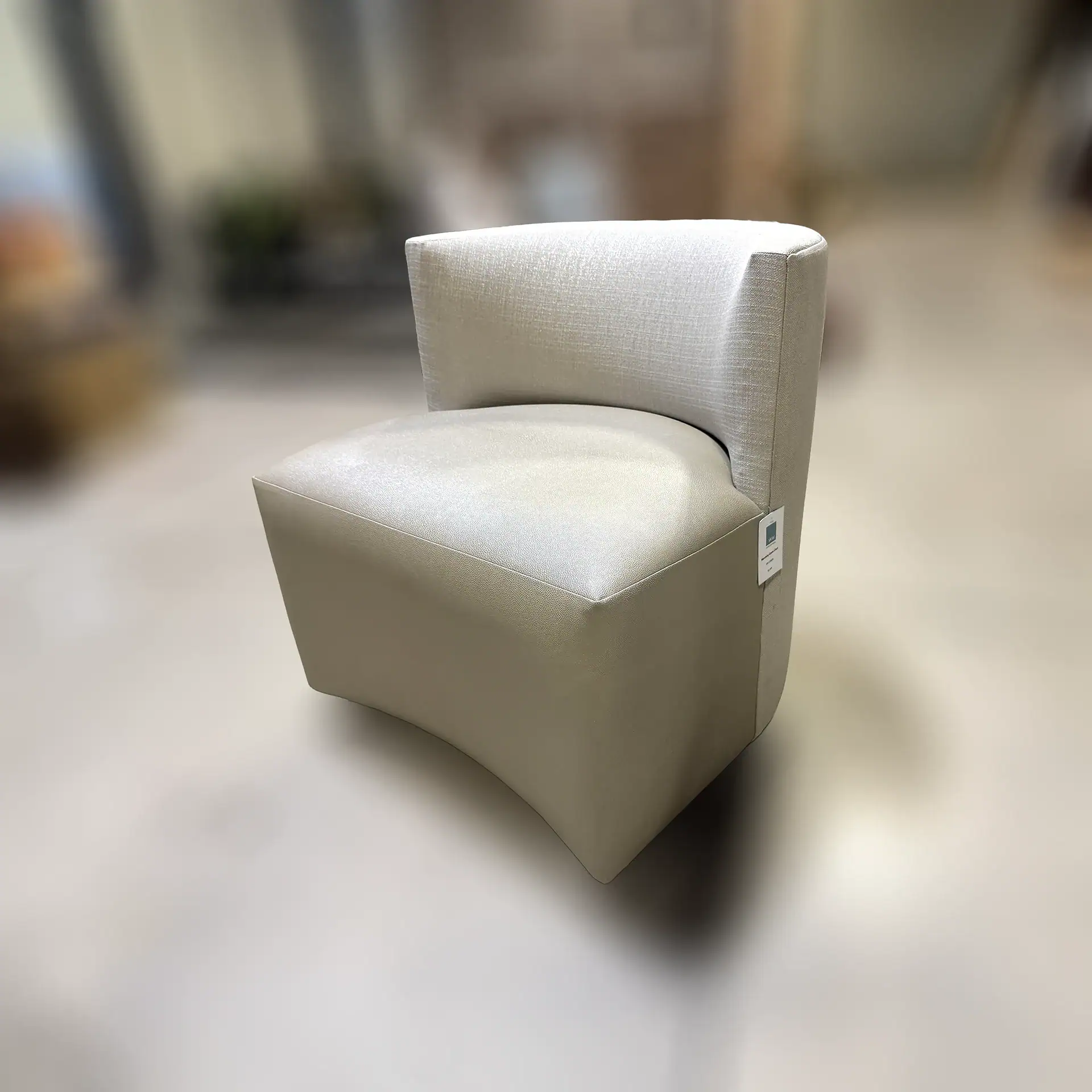 Modern Lazar Mandalay game chair with beige upholstery and curved backrest.
