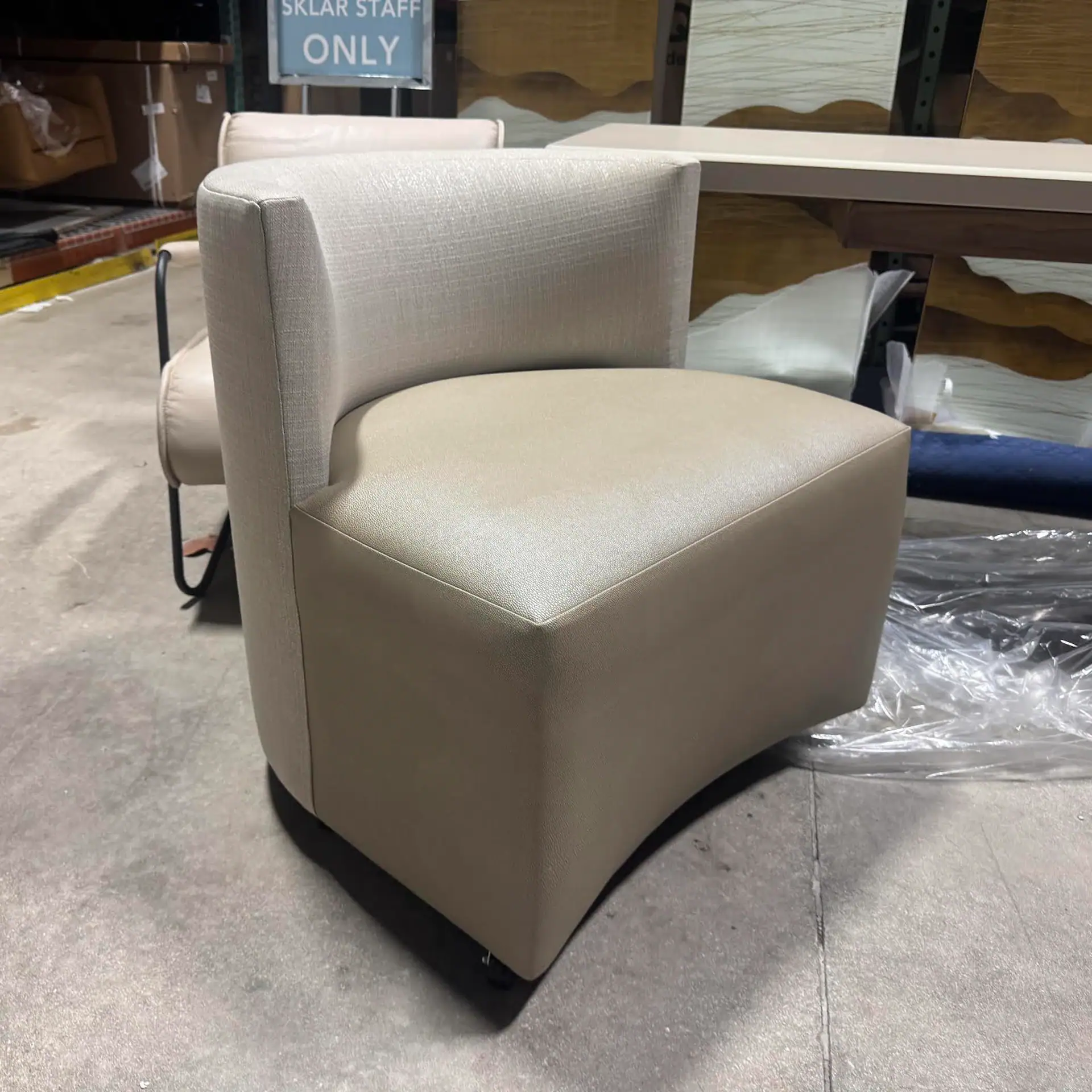 Modern Mandalay game chair with beige upholstery and curved design.