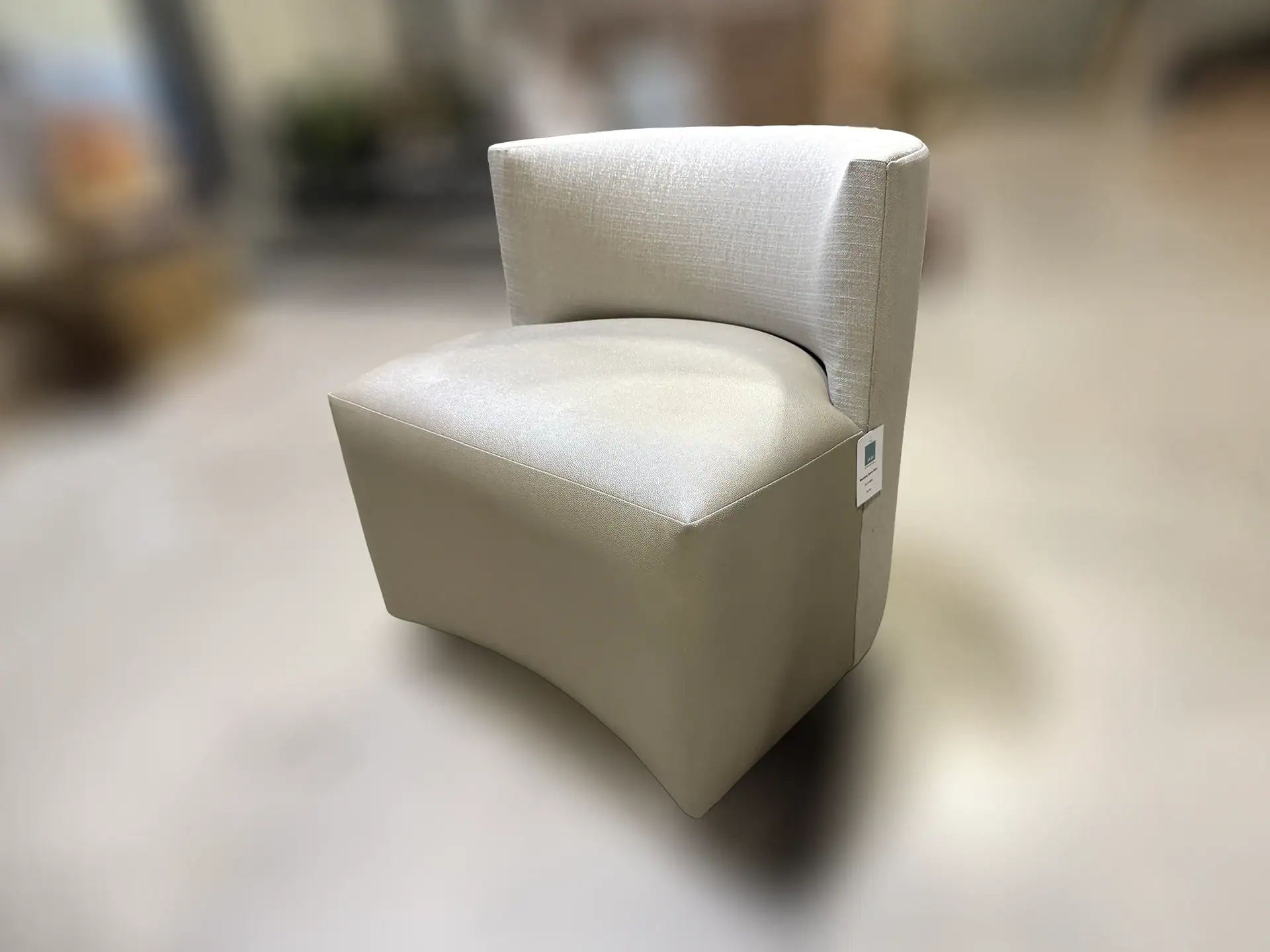 Modern beige game chair with curved backrest and plush seat.