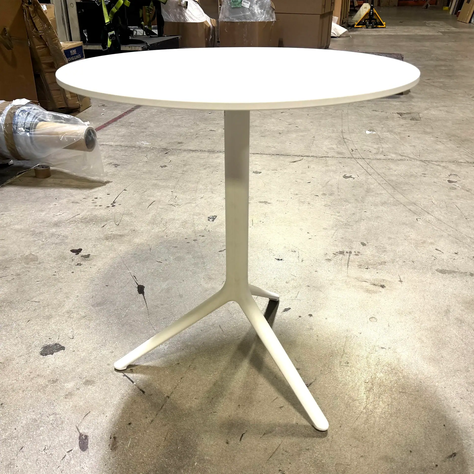 Modern outdoor table with white round top and beige base.