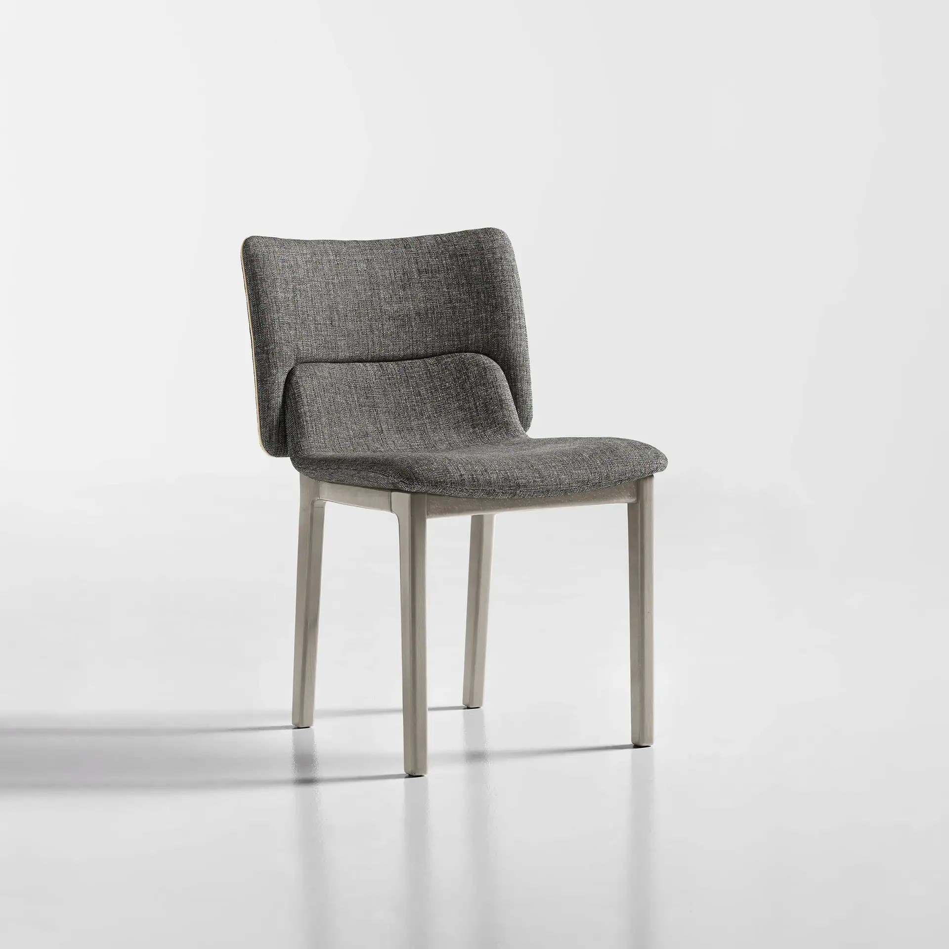 Modern grey upholstered dining chair with wooden legs, stylish and comfortable for dining rooms.