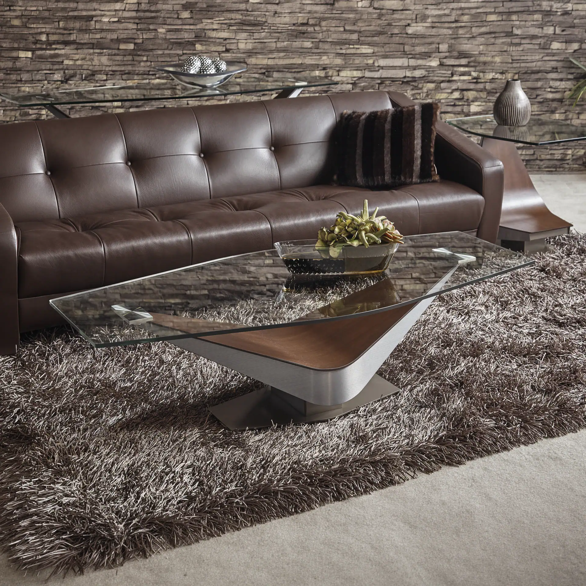 Modern leather sofa with tufted design and glass coffee table in stylish living room setting.