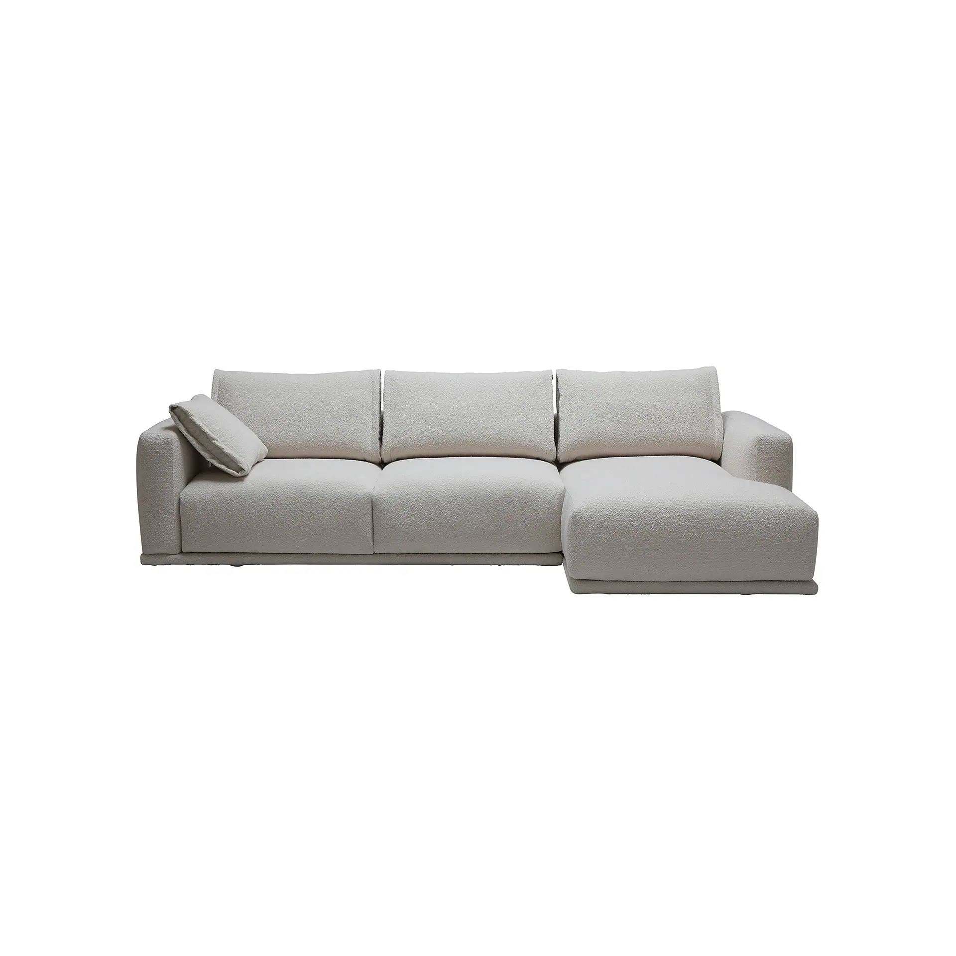 A light beige textured sectional sofa with a chaise lounge on the right and one throw pillow on the left armrest, set against a white background.