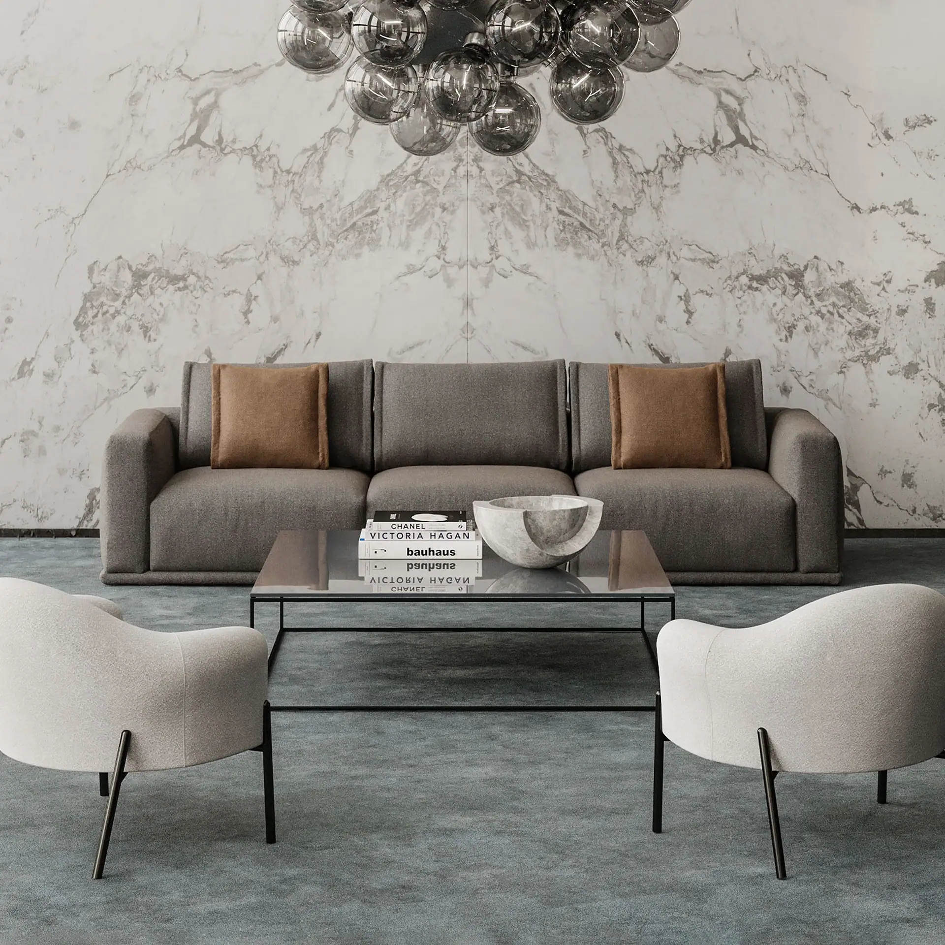A modern living room with a grey sofa, glass coffee table, two light armchairs, and a smoky globe chandelier against a white marble wall.